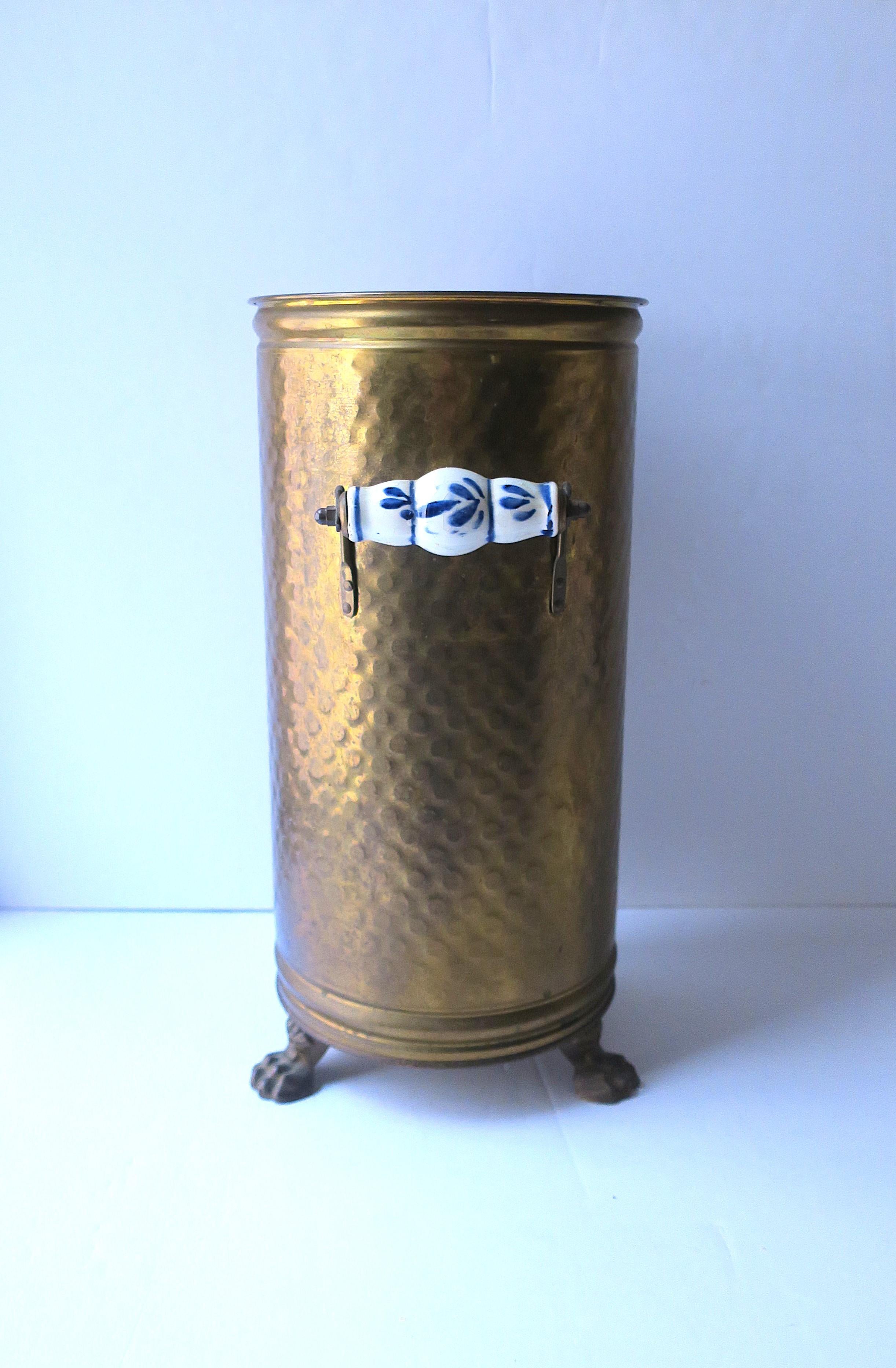 A Dutch brass umbrella stand with lion paw feet and blue and white Delft pottery handles, circa mid-20th century, Holland. Dimensions: 8.25