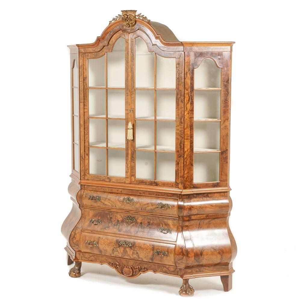 An impressive Dutch burl walnut vitrine, with upper glass sided and doors over three shaped drawers with book-matched burl veneer fronts.

Carved ball-and-claw feet, and carved top details and lower apron, circa 1920.



