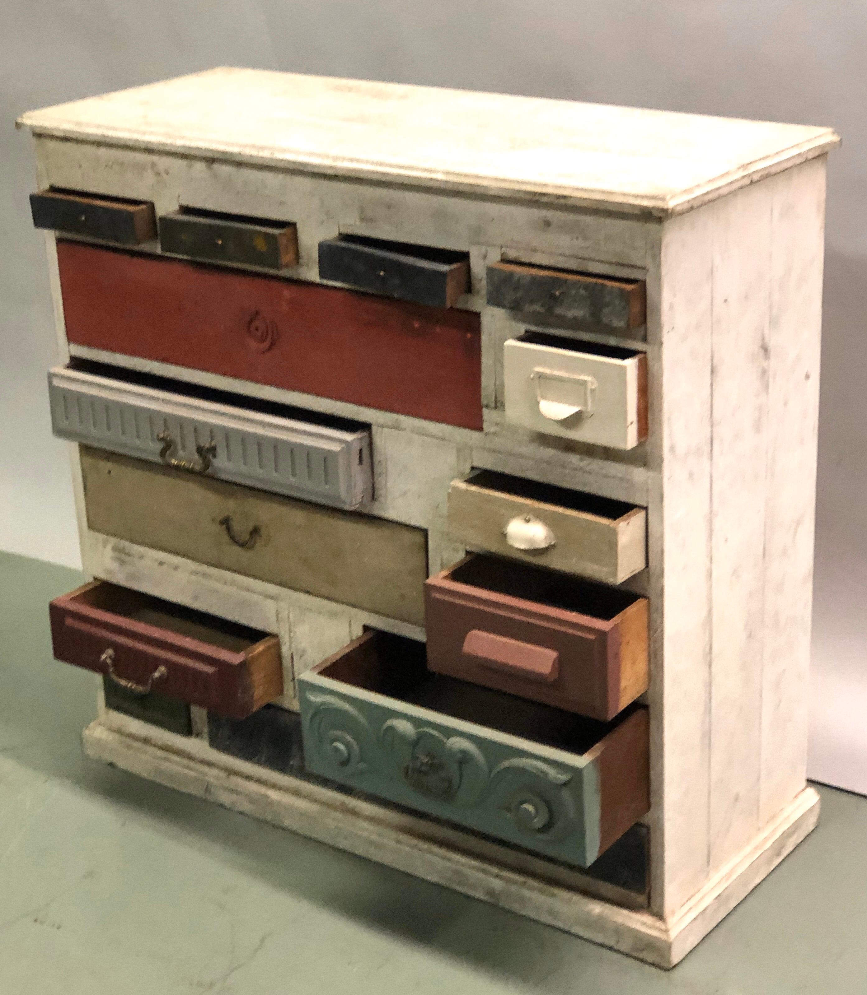 Una cassapanca o una commode o un server o una credenza o un armadietto olandesi unici nel loro genere, composti da 14 cassetti distinti e diversi tra loro, con variazioni di forma, dimensioni, età, colore, design e decorazioni che creano una
