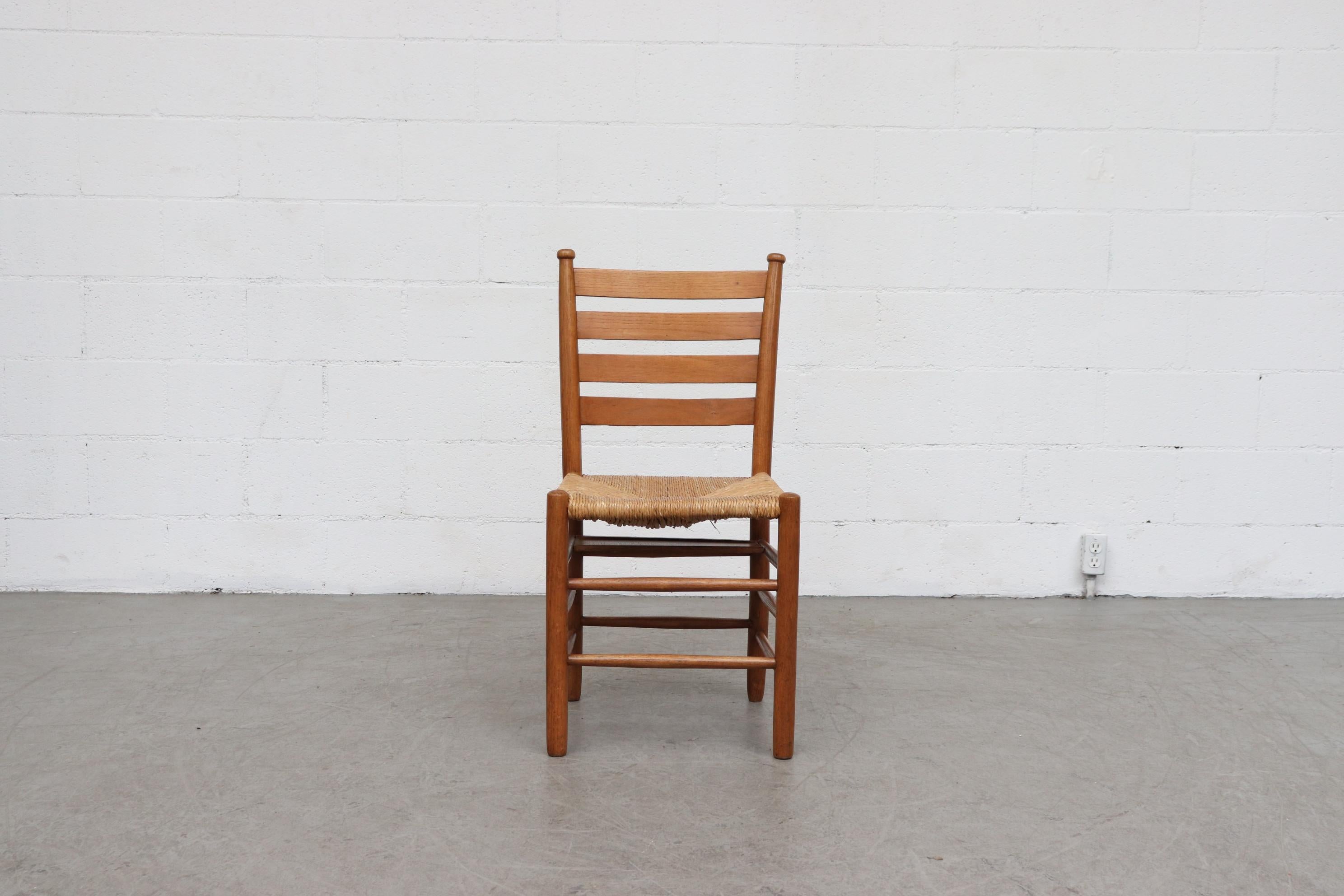 Set of 6 Quaker style dining chairs with rush seats, oak and wormwood frames from an old church in Holland. All in very original condition with visible wear, a few retain the bible shelf under the seat. Visible wear consistent with their age and