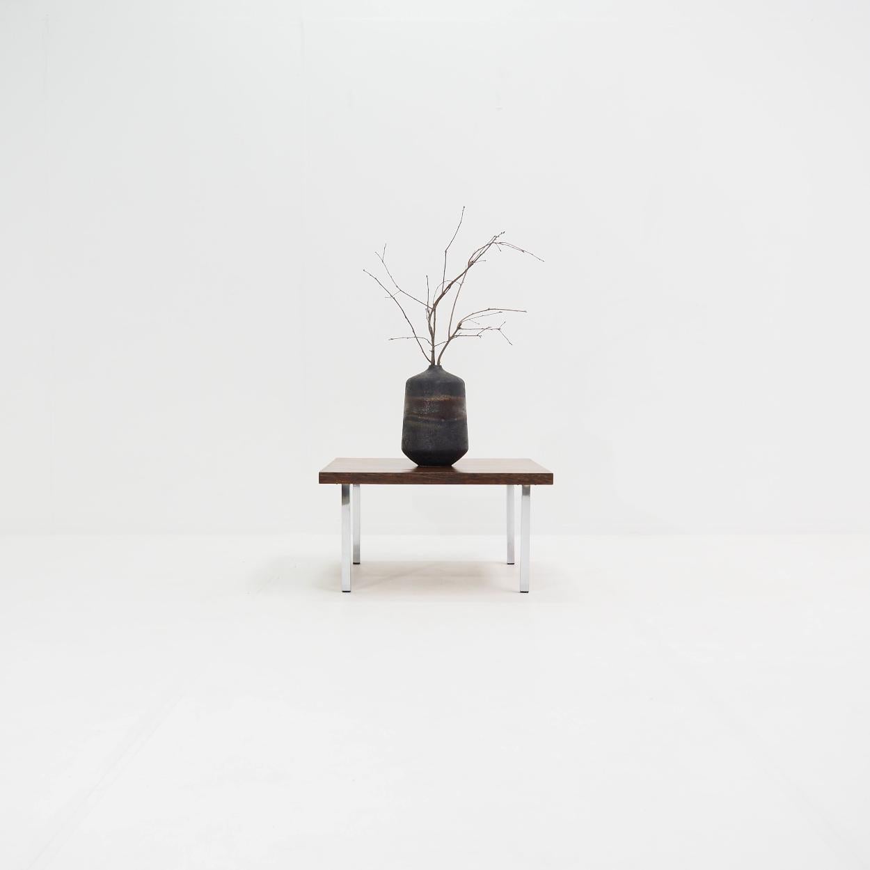 Coffee table with strong straight lines designed in the 1960s by Kho Liang Ie for the Dutch manufacturer Artifort.

The table has a square top that is made of wood veneer. It has a beautiful dark colour with an absolute minimum of wear.

Many of Kho