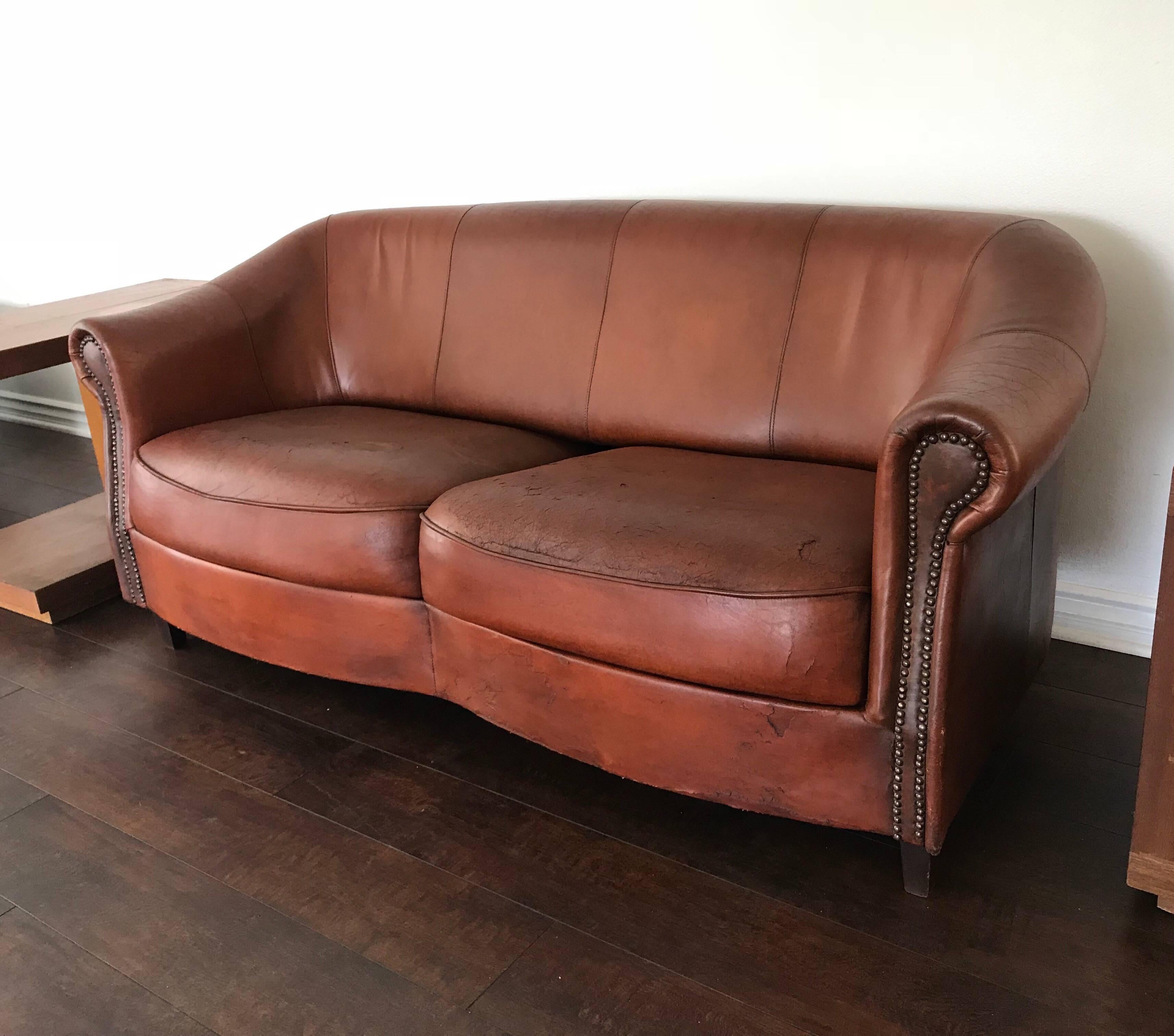 A wonderful distressed lamb skin leather sofa in a beautiful cognac color hand made by Dutch craftsman, Joris. Original tag.