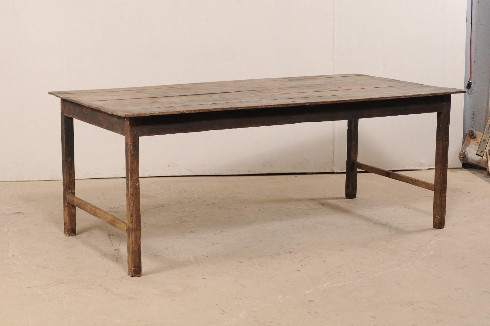 A Dutch Colonial teak wood table from the late 19th century. This antique table from Indonesia is approximately 6.5 feet in length and has a beautiful rustic appearance, designed with minimal adornment. This piece features a rectangular-shaped,