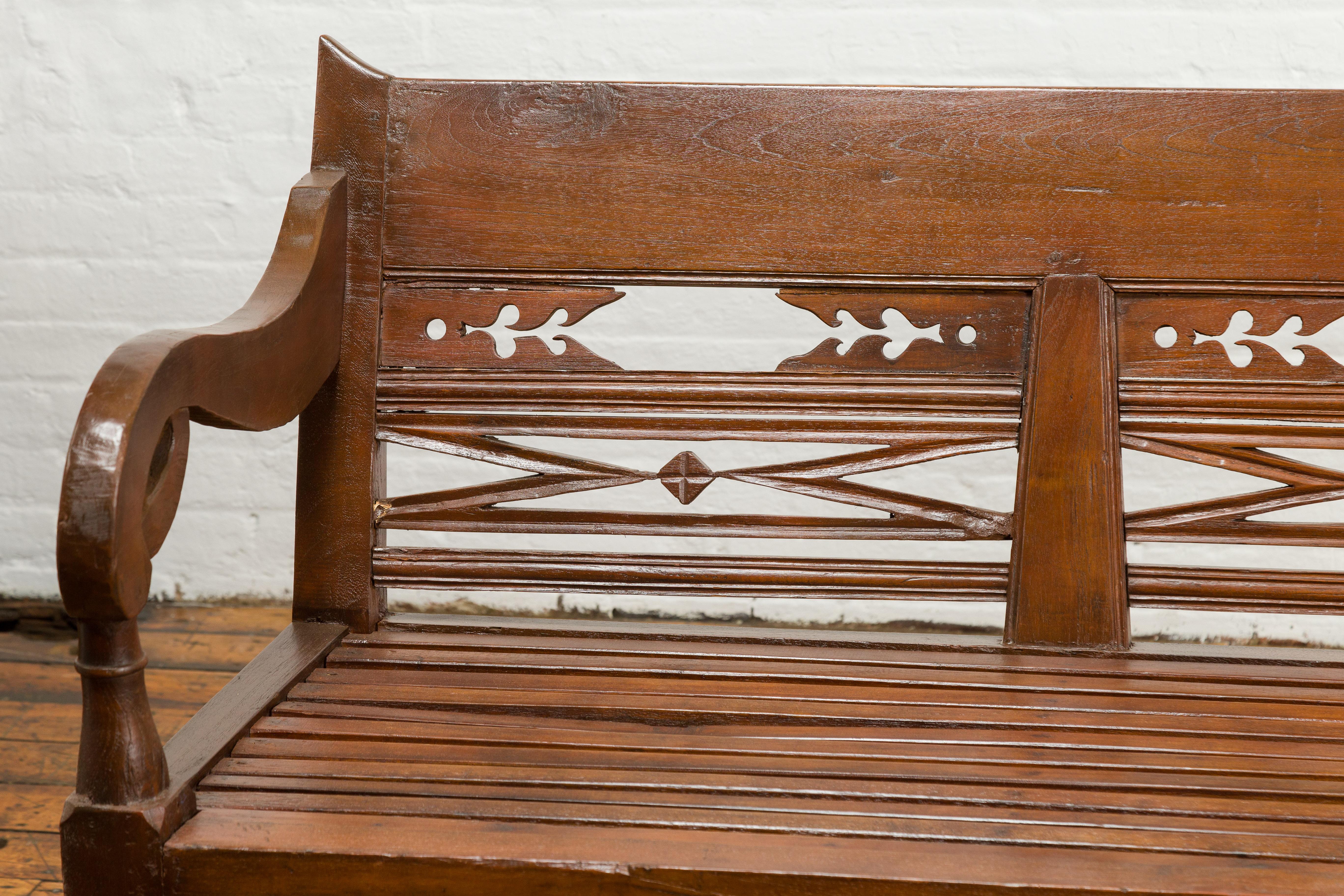 20th Century Dutch Colonial Bench with Carved Back, Scrolling Arms and Turned Baluster Legs For Sale