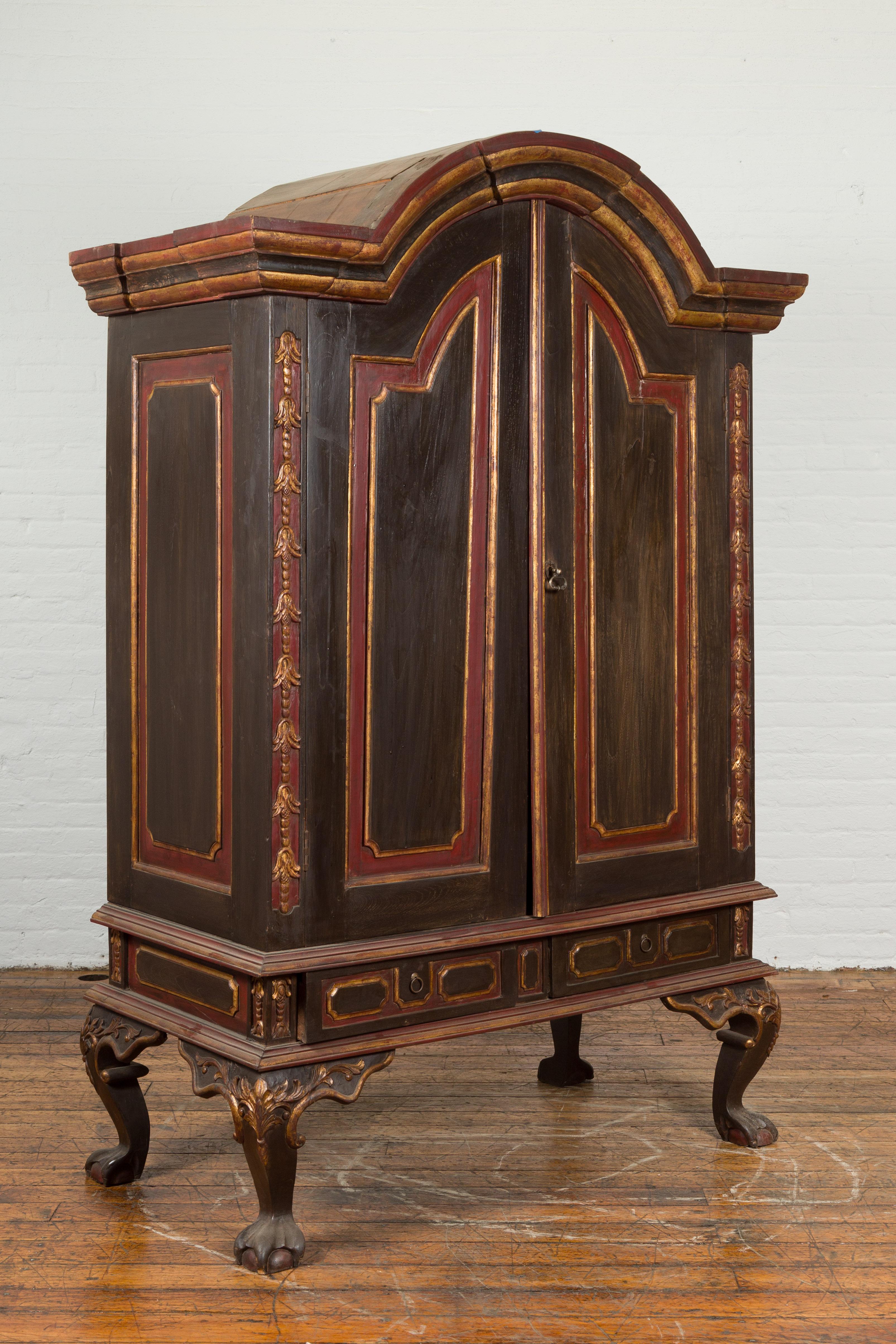 A Dutch Colonial period Indonesian hutch cabinet from the early 20th century, with bonnet top, shelves, drawers and cabriole legs. Created in Indonesia at the turn of the century, this Dutch Colonial cabinet attracts our attention with its large