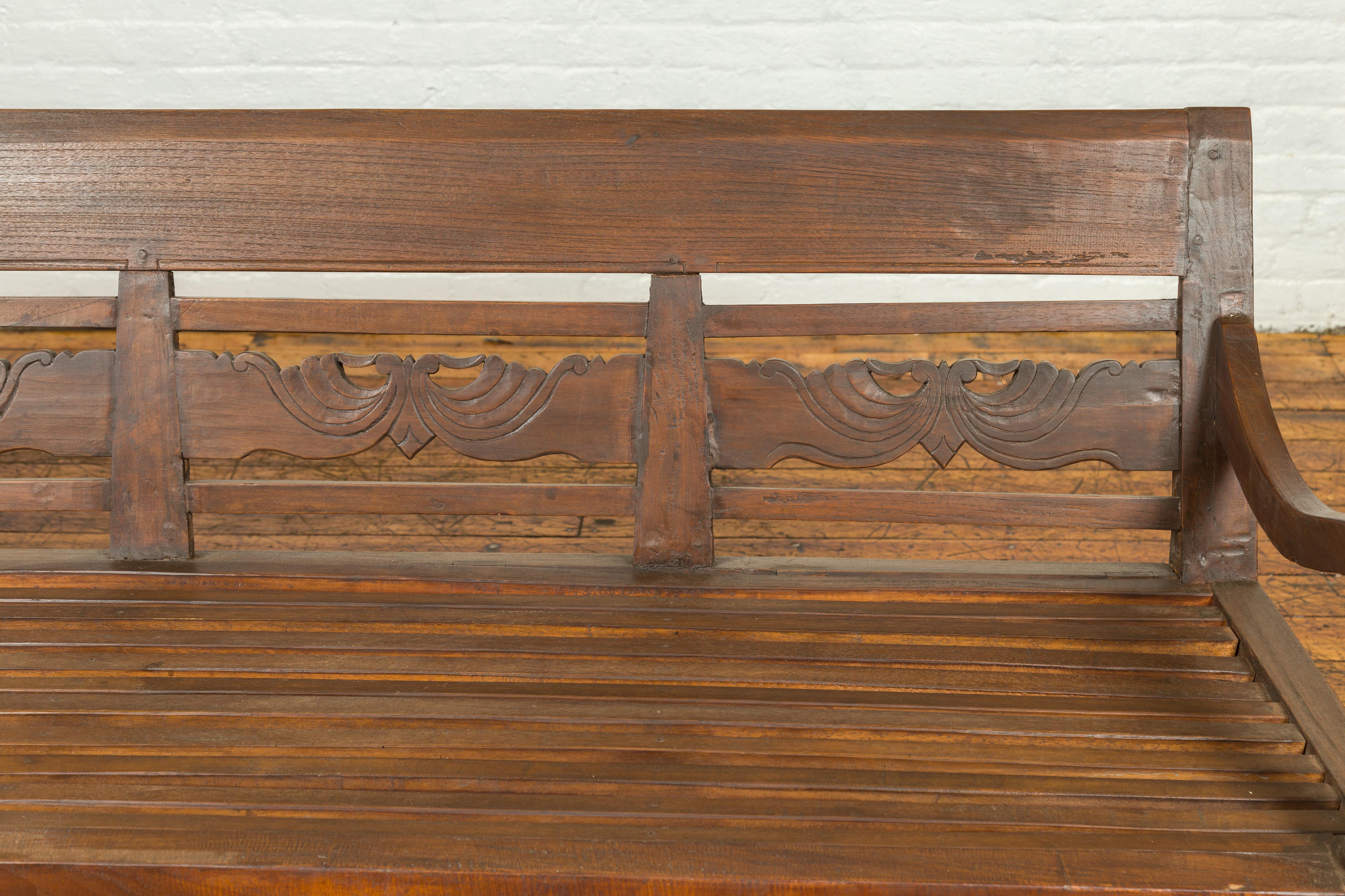 Indonesian Dutch Colonial Late 19th Century Bench with Carved Back and Scrolling Arms