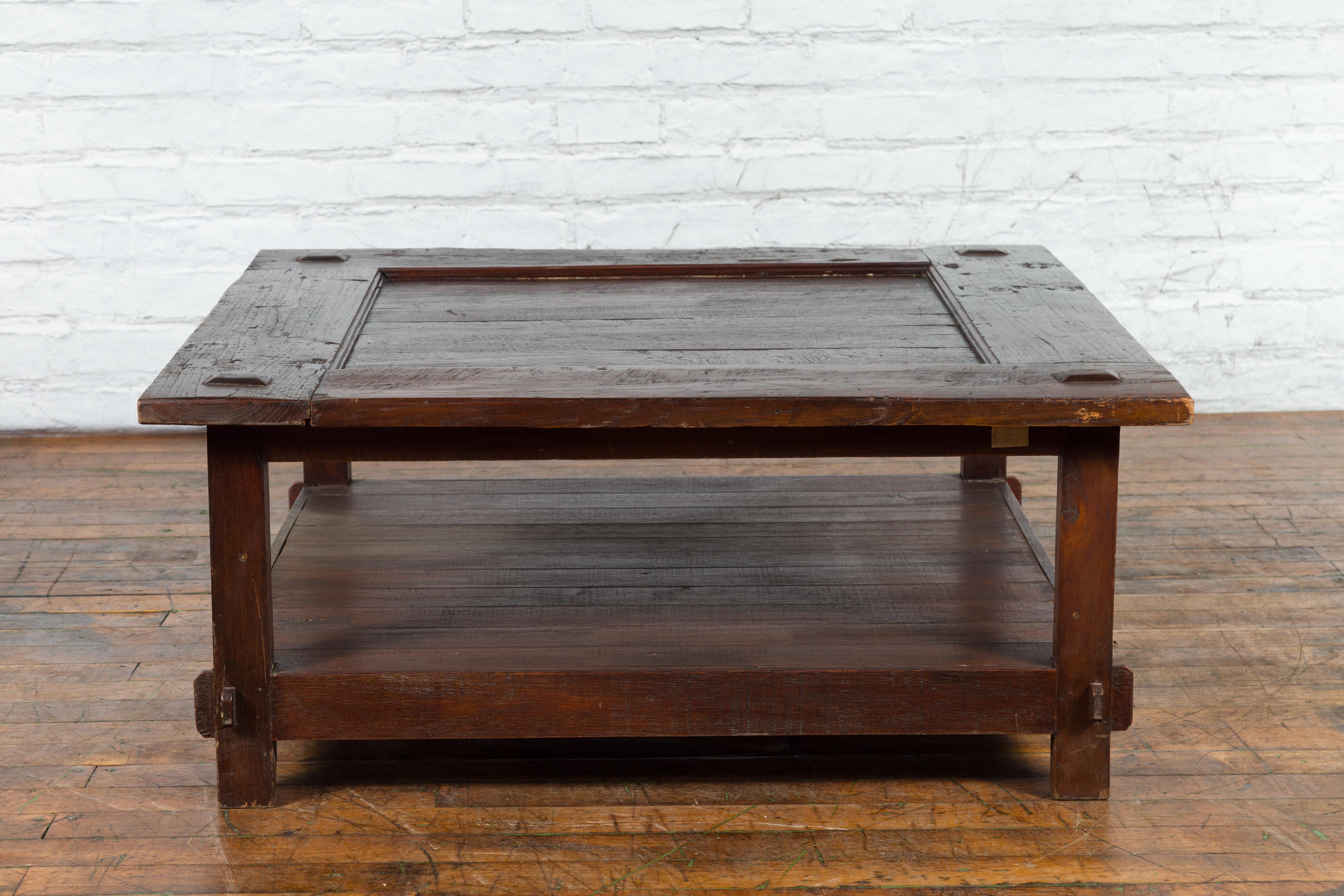 Ein antiker indonesischer Couchtisch aus der holländischen Kolonialzeit aus dem späten 19. Jahrhundert mit quadratischer Platte, hervorstehenden Akzenten, unterer geplanter Ablage und geraden Beinen. Dieser Tisch aus der niederländischen