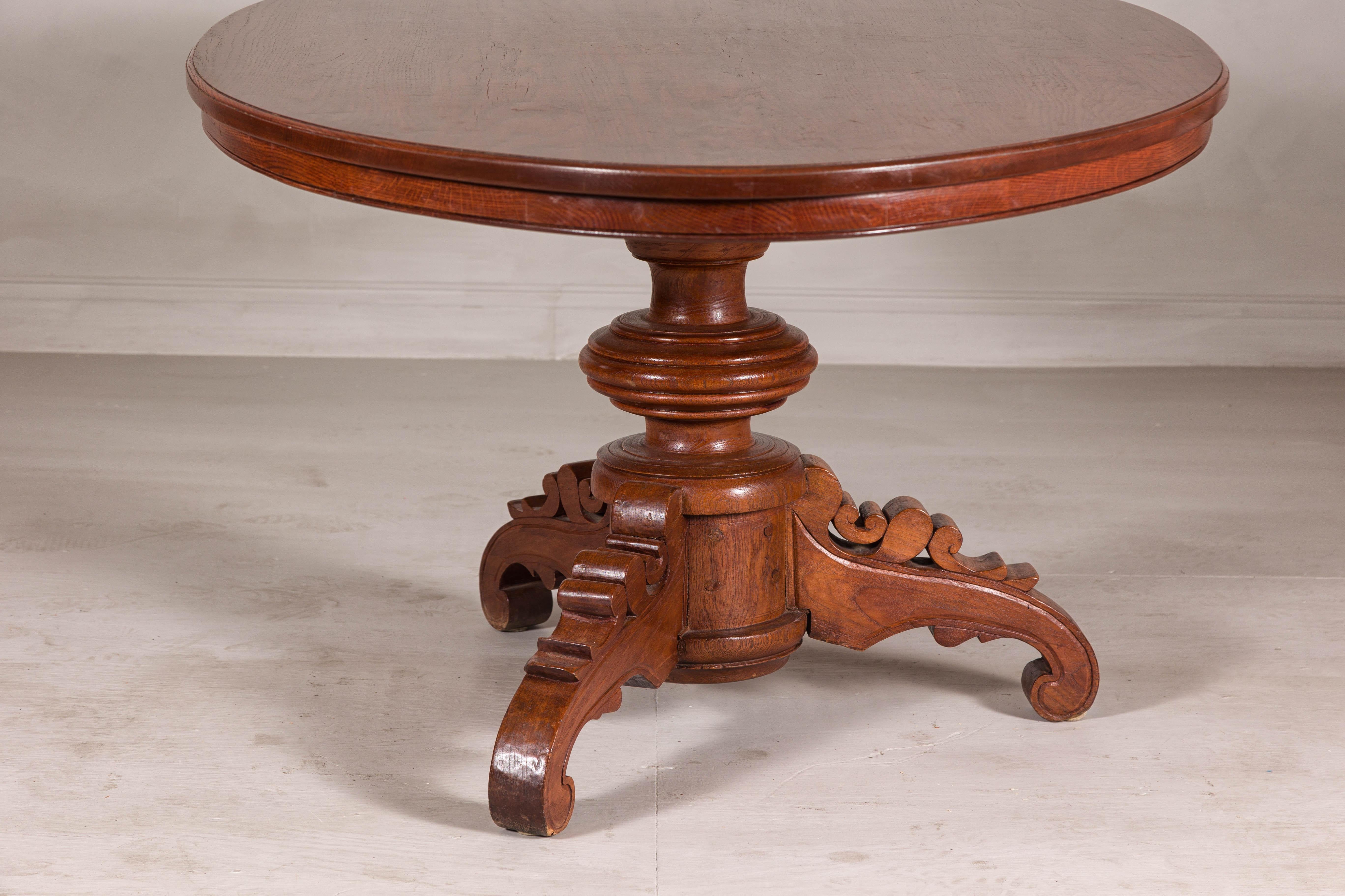 Carved Dutch Colonial Oval Pedestal Dining Table with Scrolling Base, Late 19th Century For Sale