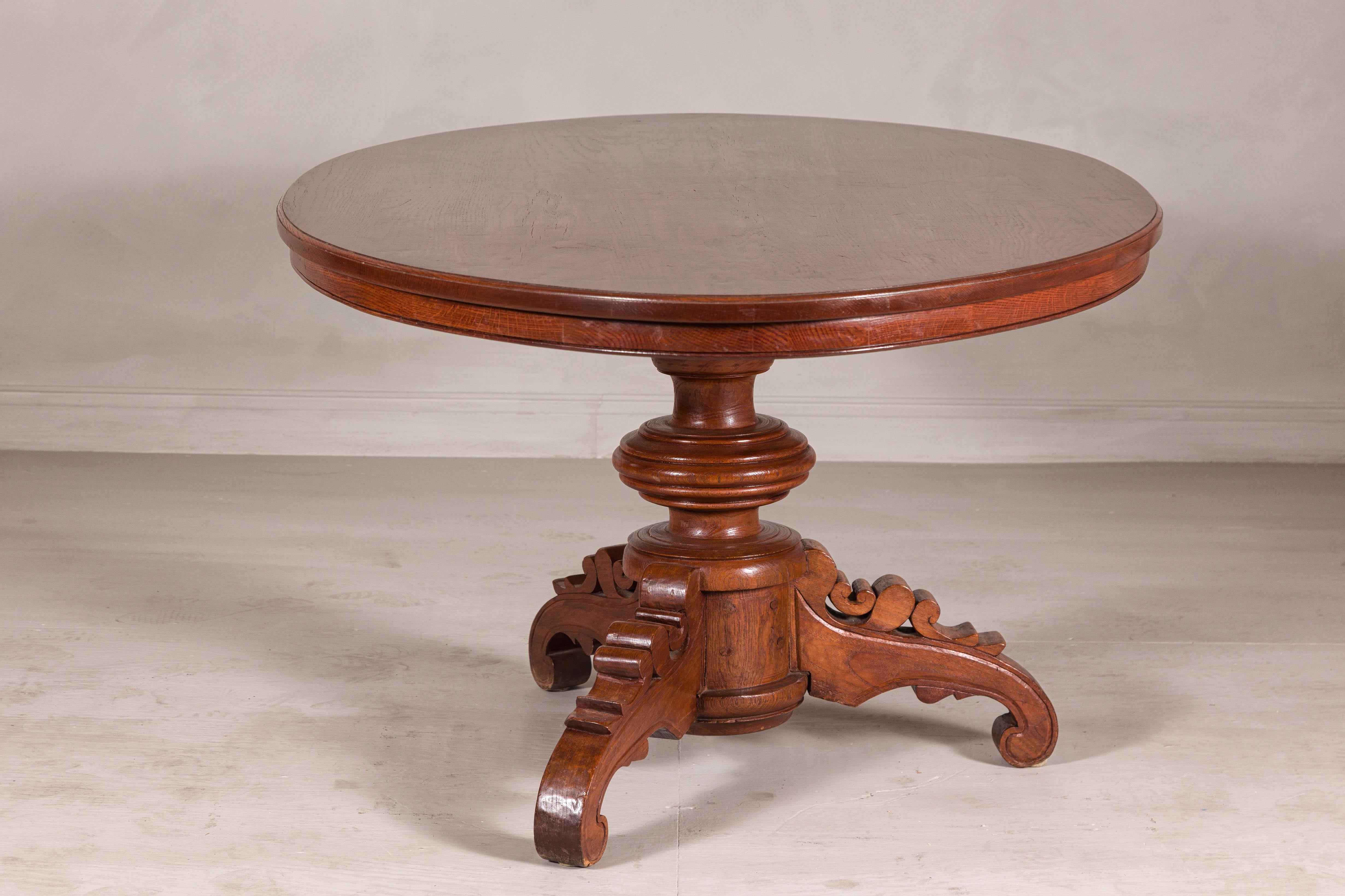 Wood Dutch Colonial Oval Pedestal Dining Table with Scrolling Base, Late 19th Century For Sale