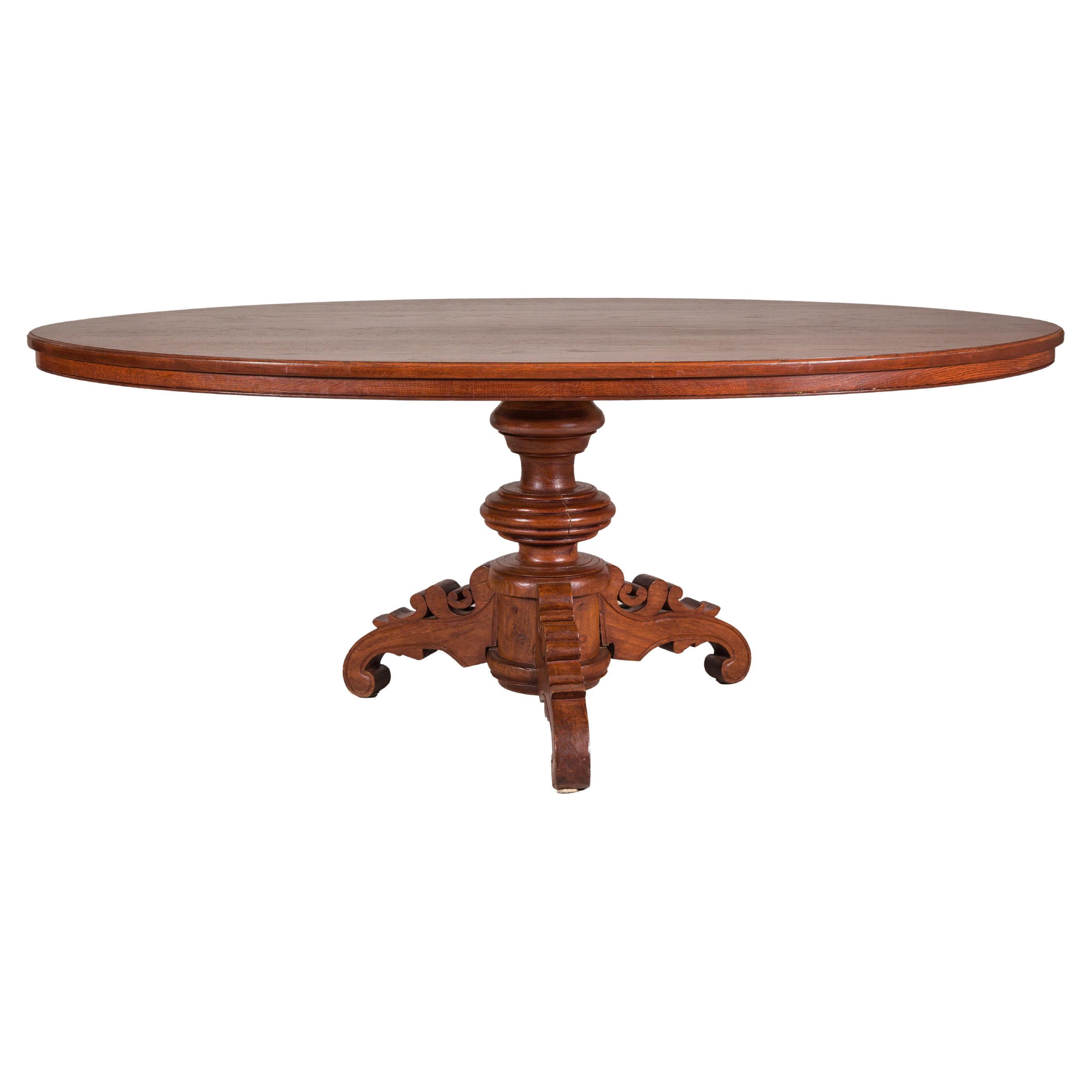 Dutch Colonial Oval Pedestal Dining Table with Scrolling Base, Late 19th Century For Sale