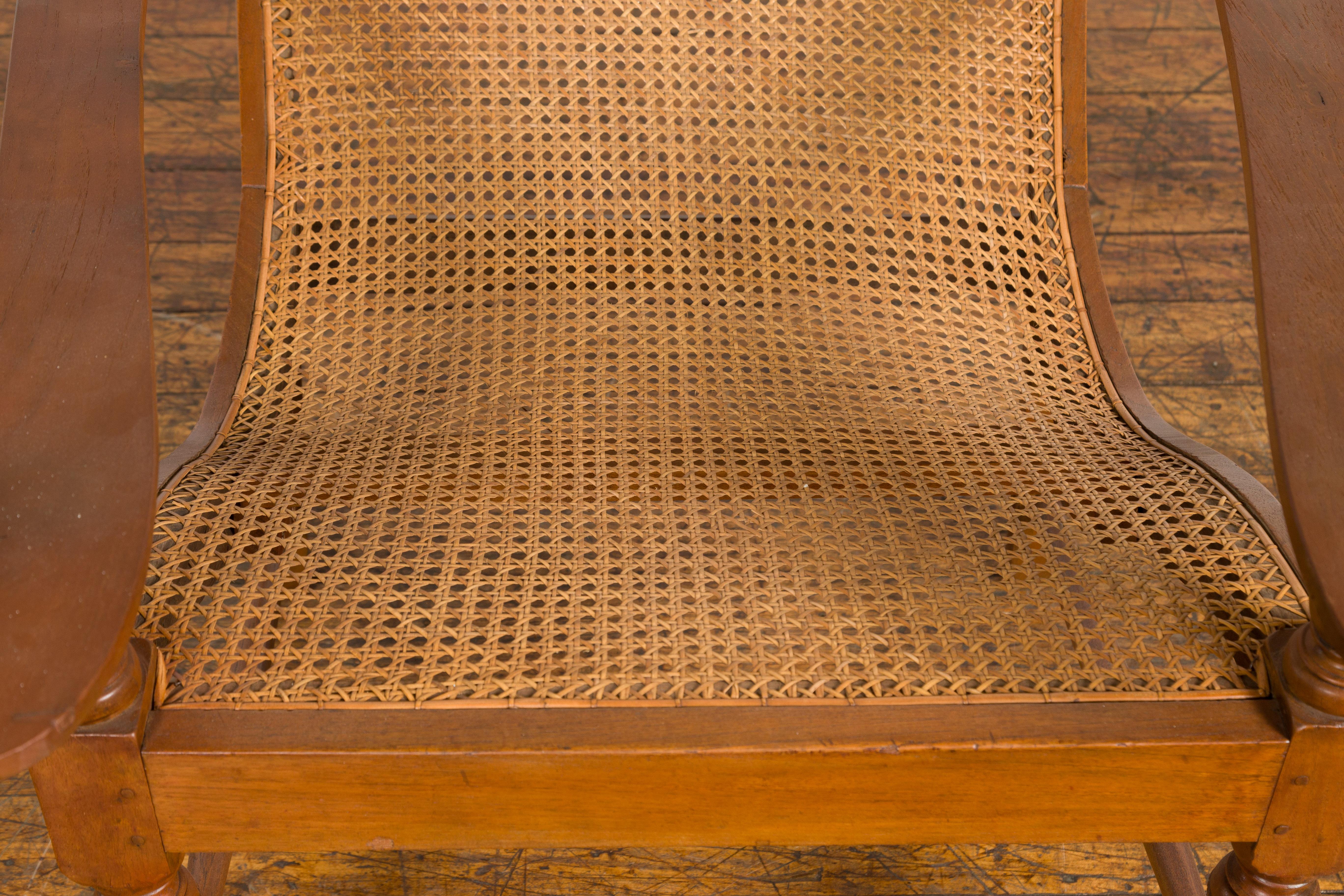 Indonesian Antique Lounge Chair with Curved Seat and Extended Back For Sale