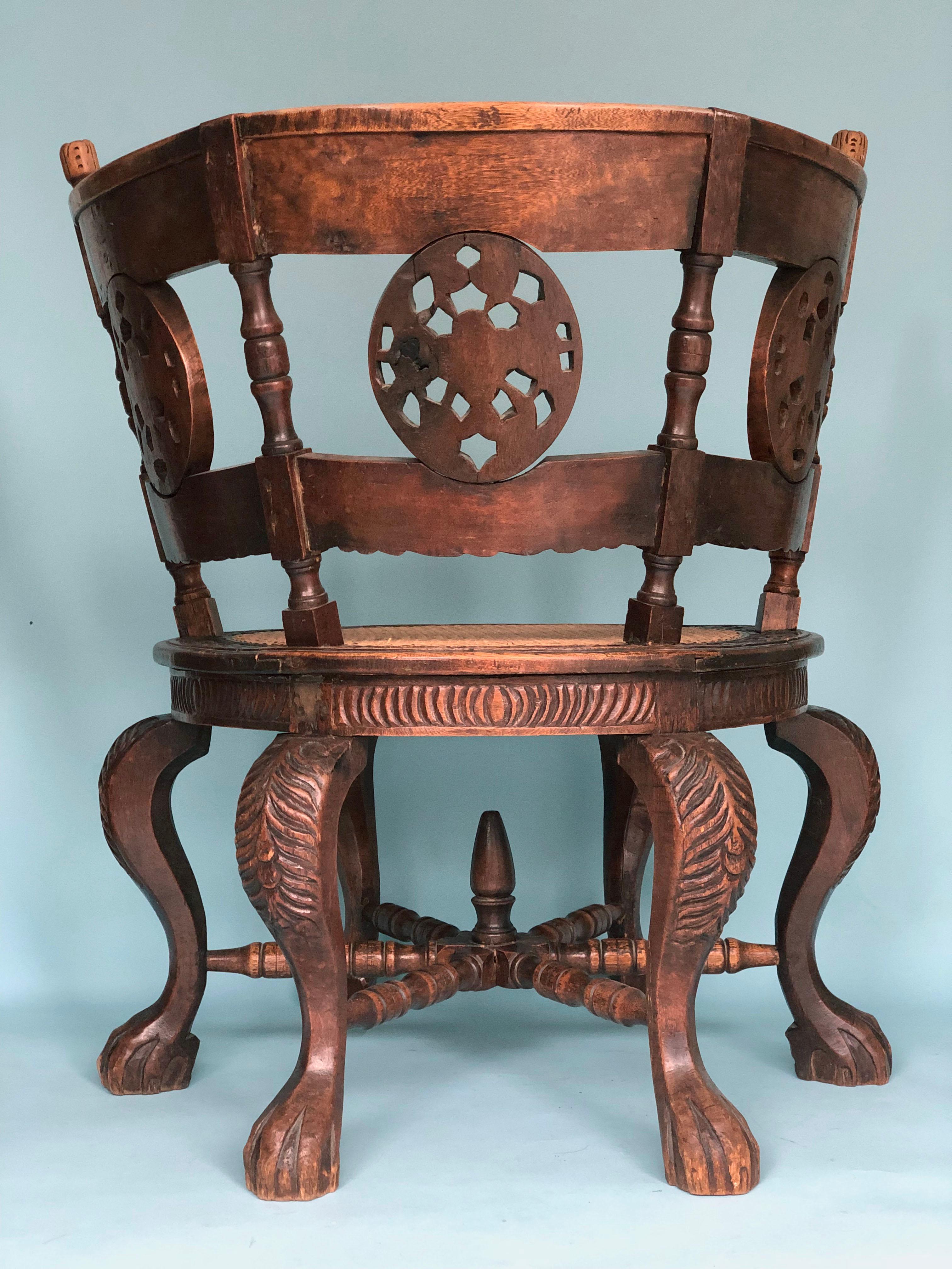 Cette magnifique chaise coloniale Burgomaster repose sur six pieds cabriole avec des pattes de lion, et possède un dossier semi-circulaire décoré de médaillons et de fleurs sculptés. Ce type de mobilier a été développé à la fin du XVIIe siècle dans
