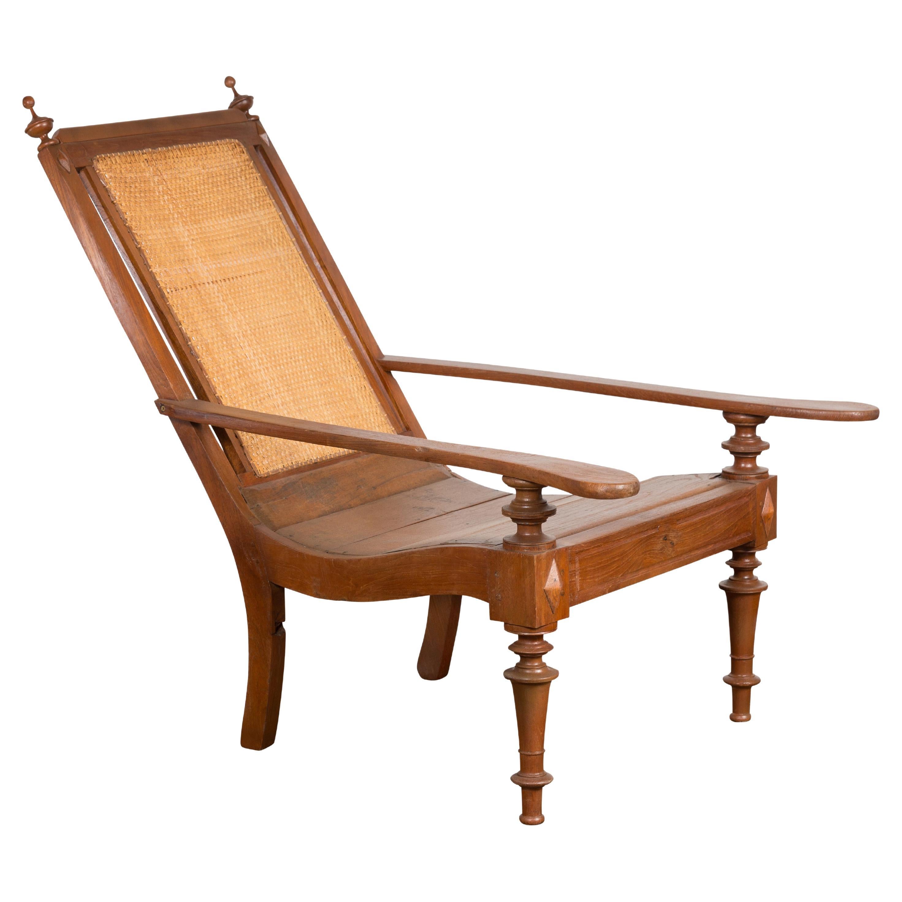 Dutch Colonial Wood and Rattan Lounge Chair with Slanted Back and Carved Finials For Sale
