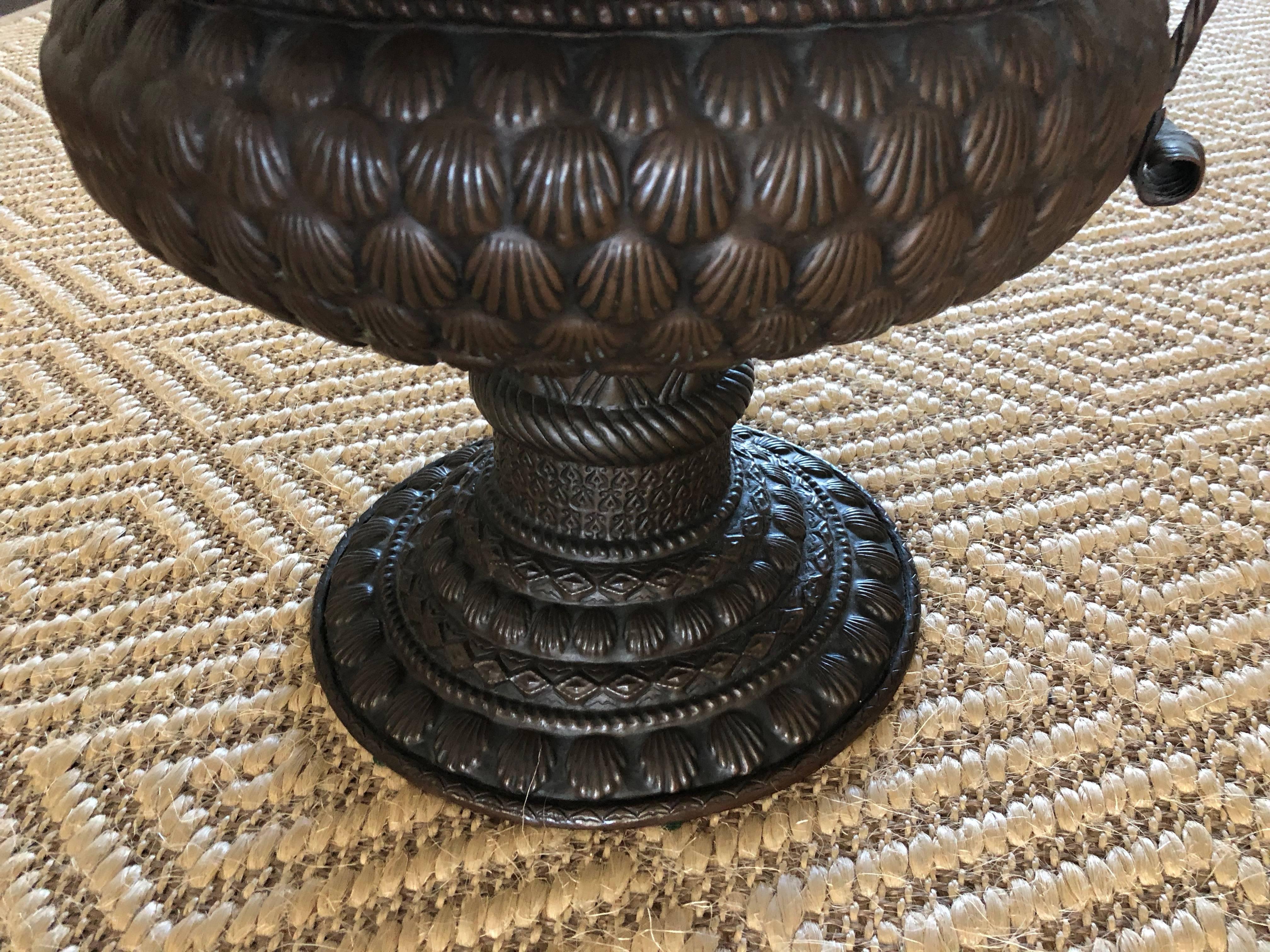 A mid-17th century Dutch copper vase or container hand made with a shell embossed designed is a goblet shaped piece. The bulbous bowl embossed with shells has a stem with rope-like knotted handles supported on a shell embossed stepped foot wonderful