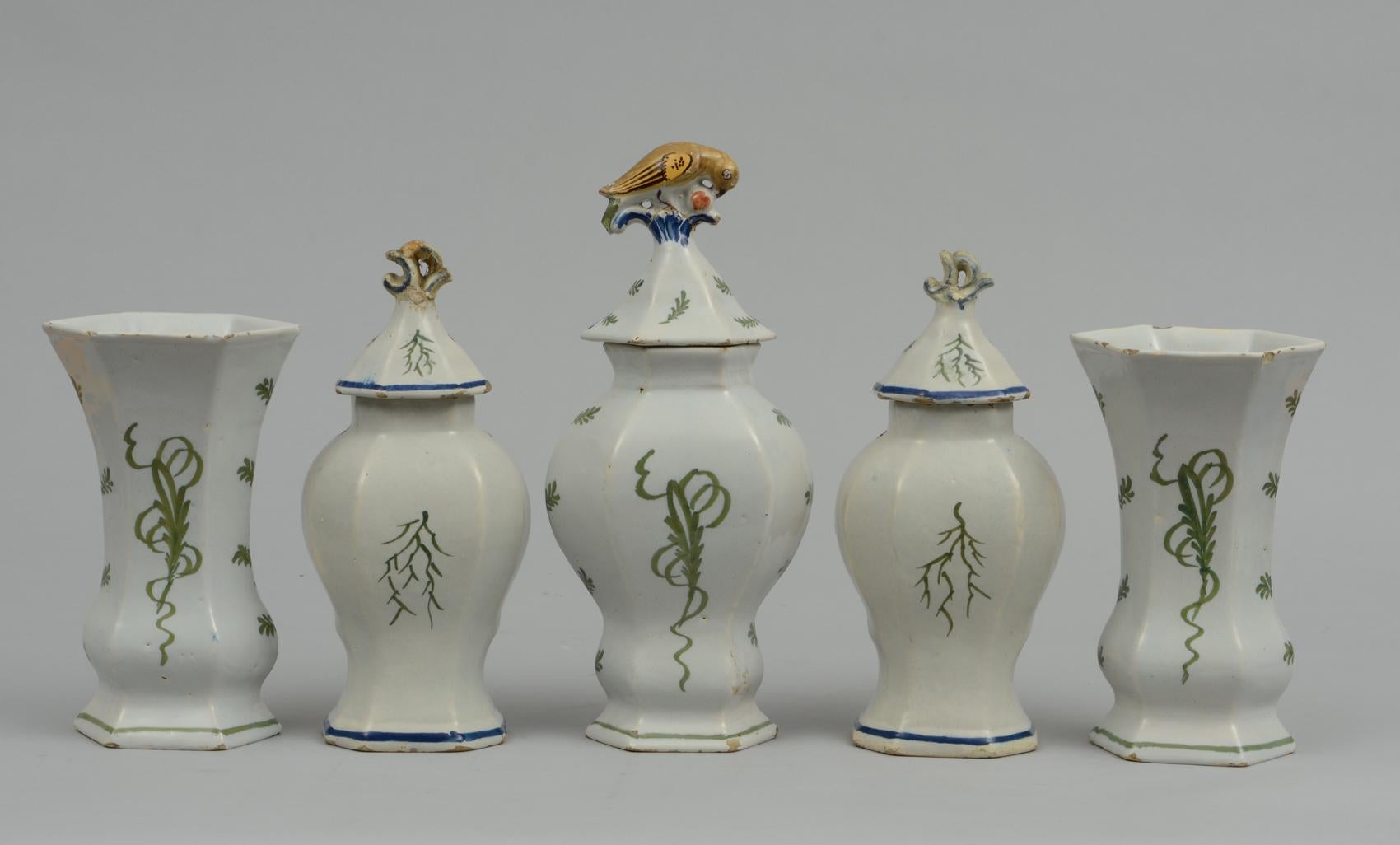 Assembled five-piece Dutch delft vase garniture, all polychrome decorated. Three vases depicting ships, the sea, cliffs and a castle in gold, blue and green. Two vases decorated with figures in a pastoral scene with a windmill in the background.