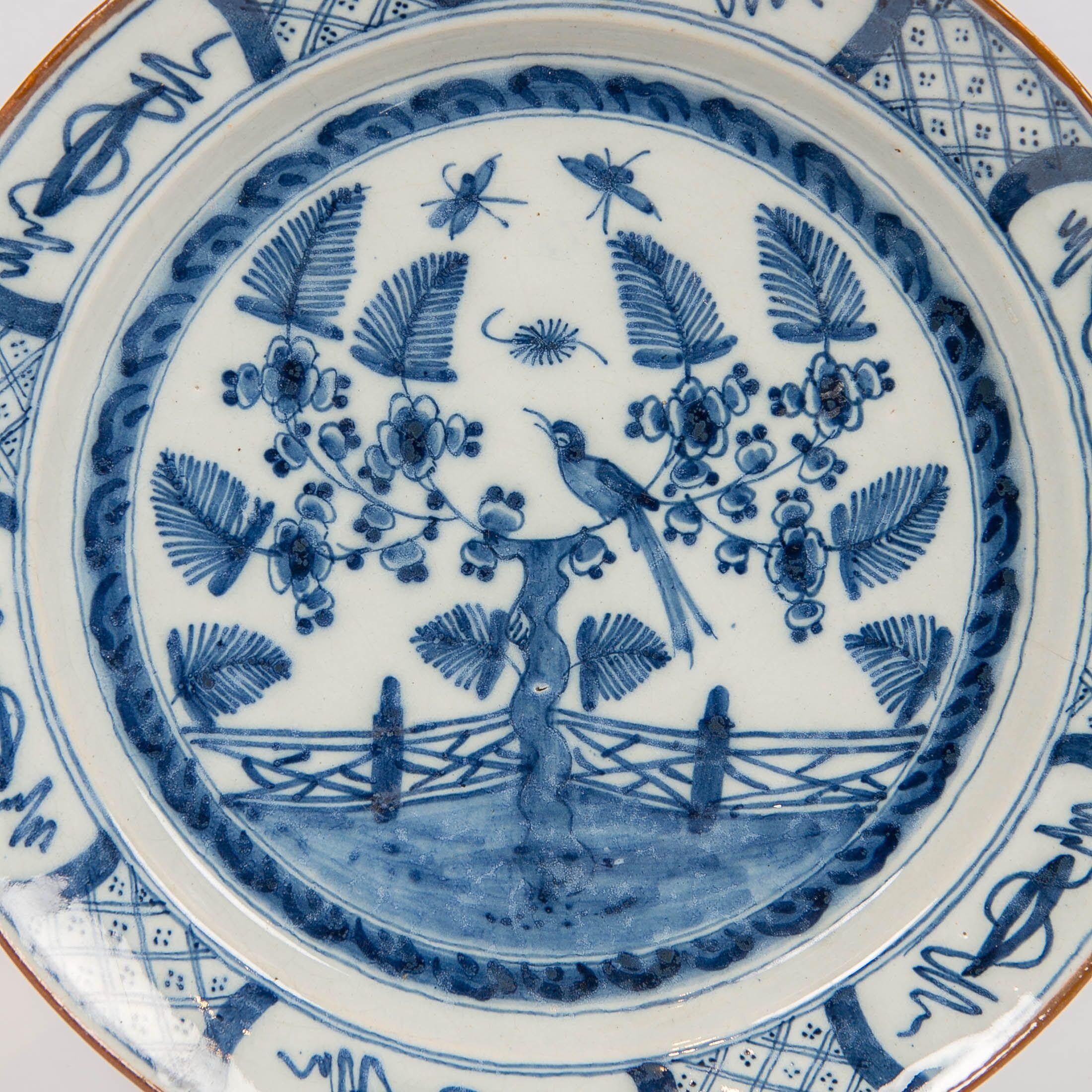 We are pleased to present this 18th-century Dutch Delft Blue and White charger made circa 1770. It is decorated with a garden scene showing a songbird perched in a flowering tree with butterflies flying above the garden.
The border is decorated with