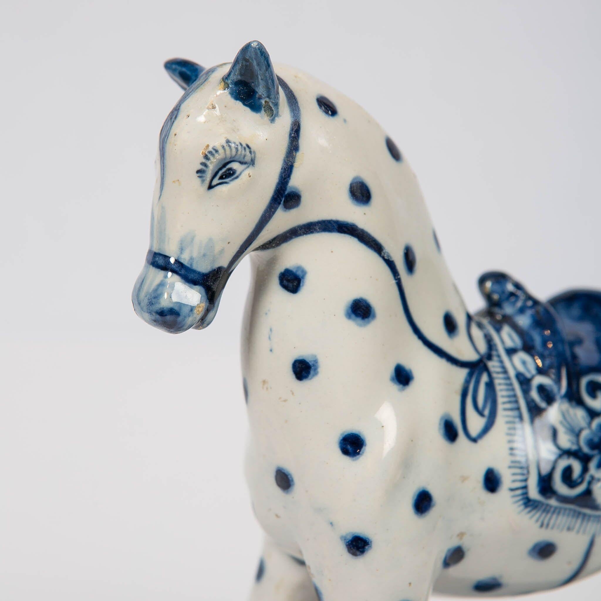 Provenance: Collection Vecht Amsterdam
A lovely 18th century Dutch Delft blue and white spotted horse is modeled prancing on a rectangular blue base. His ears point straight up; his head tilts slightly to one side as though he hears something. A