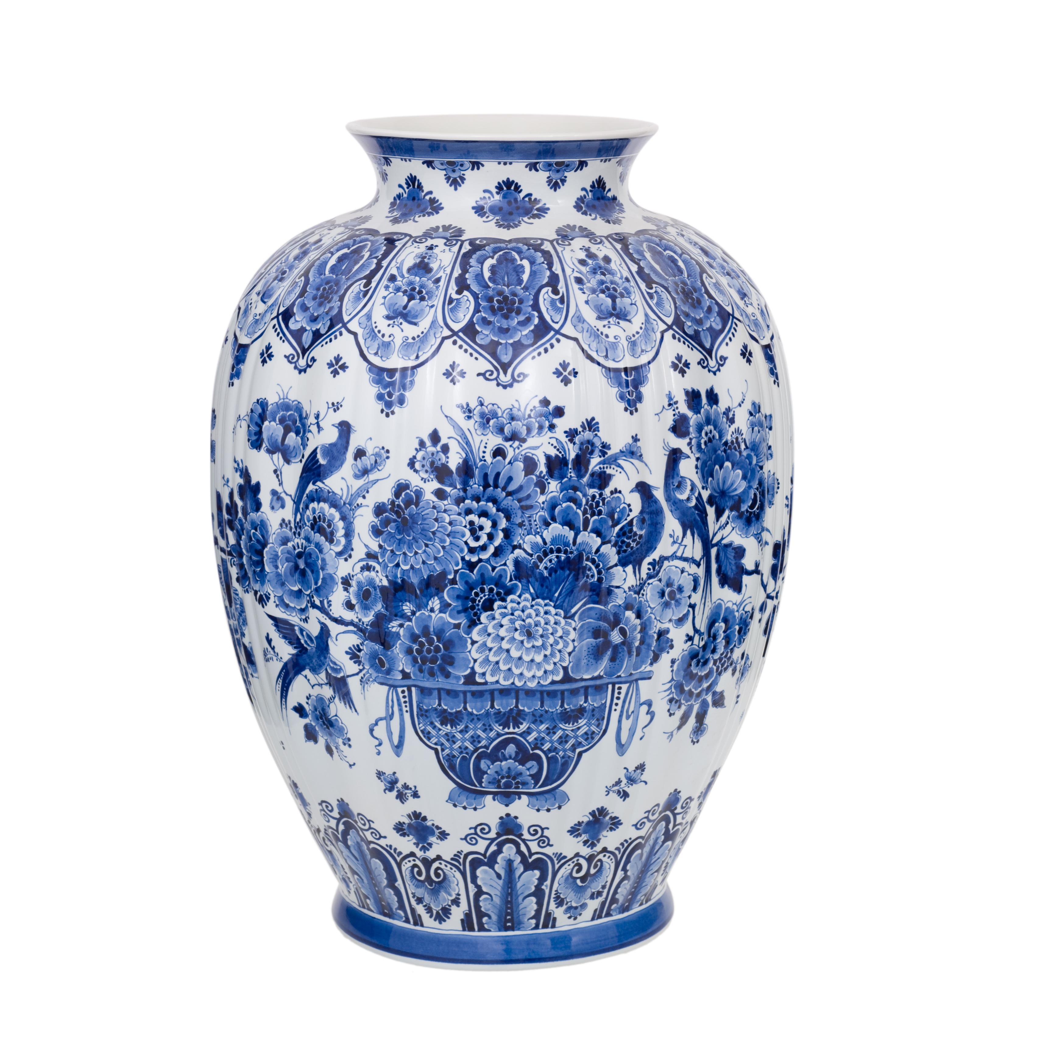 Exclusivement fabriqué à la main dans l'atelier de Royal Delft aux Pays-Bas. Ce vase est peint à la main par l'un des maîtres peintres de Royal Delft. Le vase est richement décoré d'un panier floral et d'un motif d'oiseaux dans la couleur bleue de