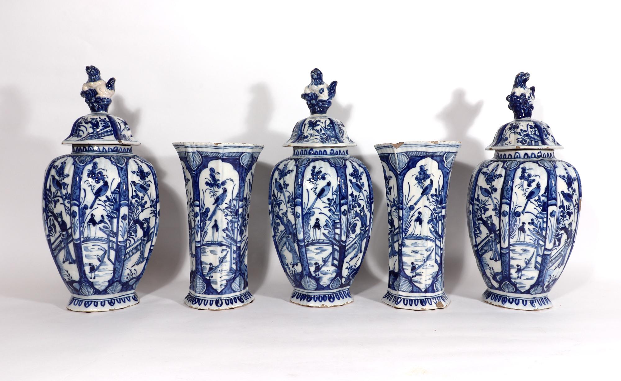 Dutch Delft blue & white chinoiserie Garniture of vases,
circa 1765

The underglaze blue octagonal-shaped vases have alternating panels, one with a Chinese male figure gardening by a fence with a large bird perched above. The other panel with a