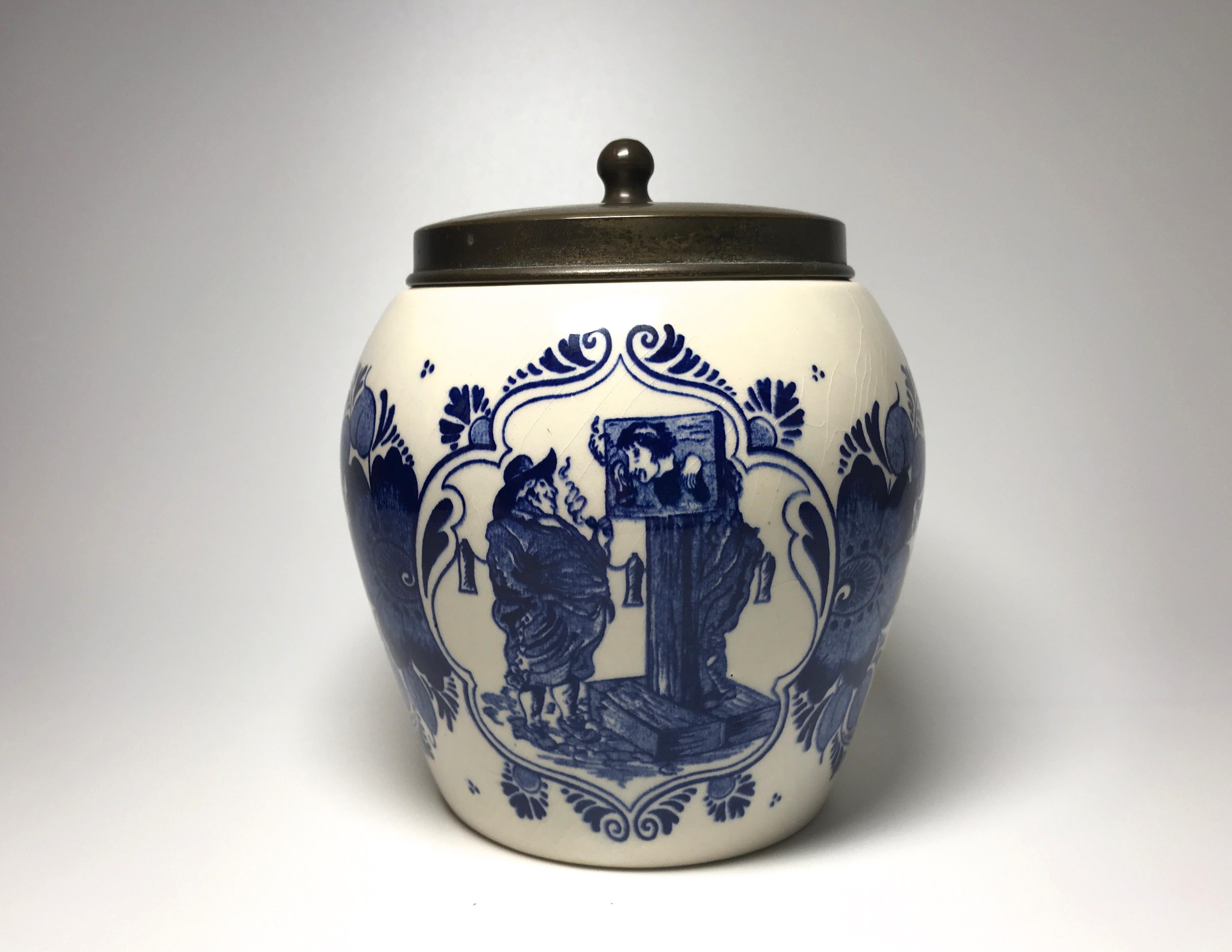 Dutch Delft comical ceramic hand painted humidor tobacco jar with brass lid
Decorated with portly gentleman and a less fortunate man in the stocks. On the reverse is the inscription, 'van Rossem's Toeback, Anno 1750'
This was purchased in The