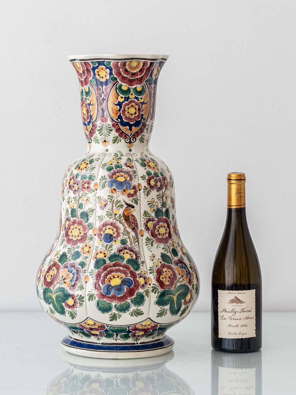 This distinctly shaped Delft-style polychrome vase exemplifies the bold, exuberant artistry of mid-century Velsen Delft pottery. Featuring a sculptural double-gourd silhouette variation—a form that expands generously at the shoulder and foot with a