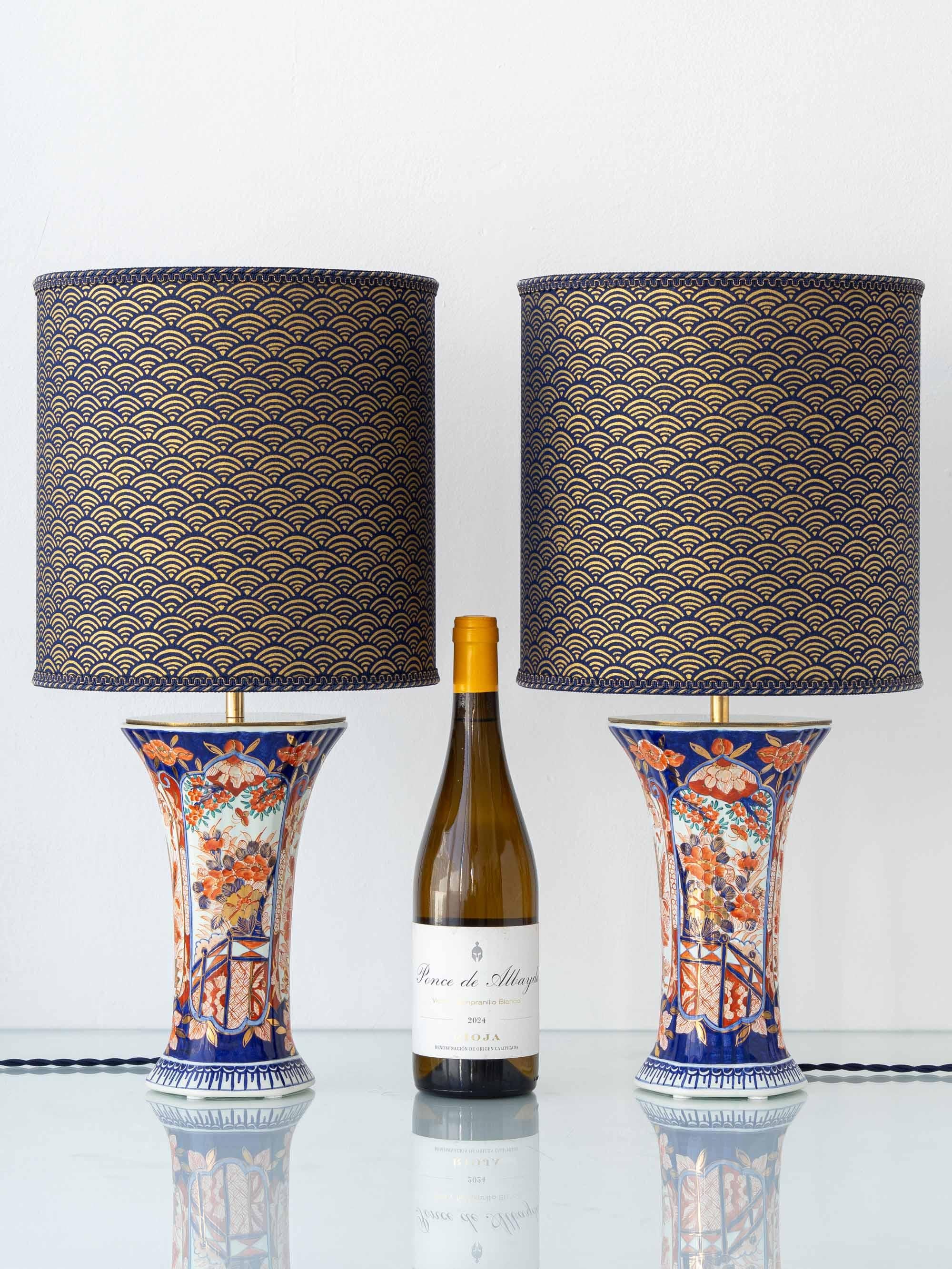 Méticuleusement réalisée à la main par le Studio Amitābha à partir d'une paire de vases Delft Imari de Jaap Heinen (Heinen Delfts Blauw), associée à des abat-jour sur mesure en tambour japonais seigaiha marine et or.

Cette paire de lampes de table