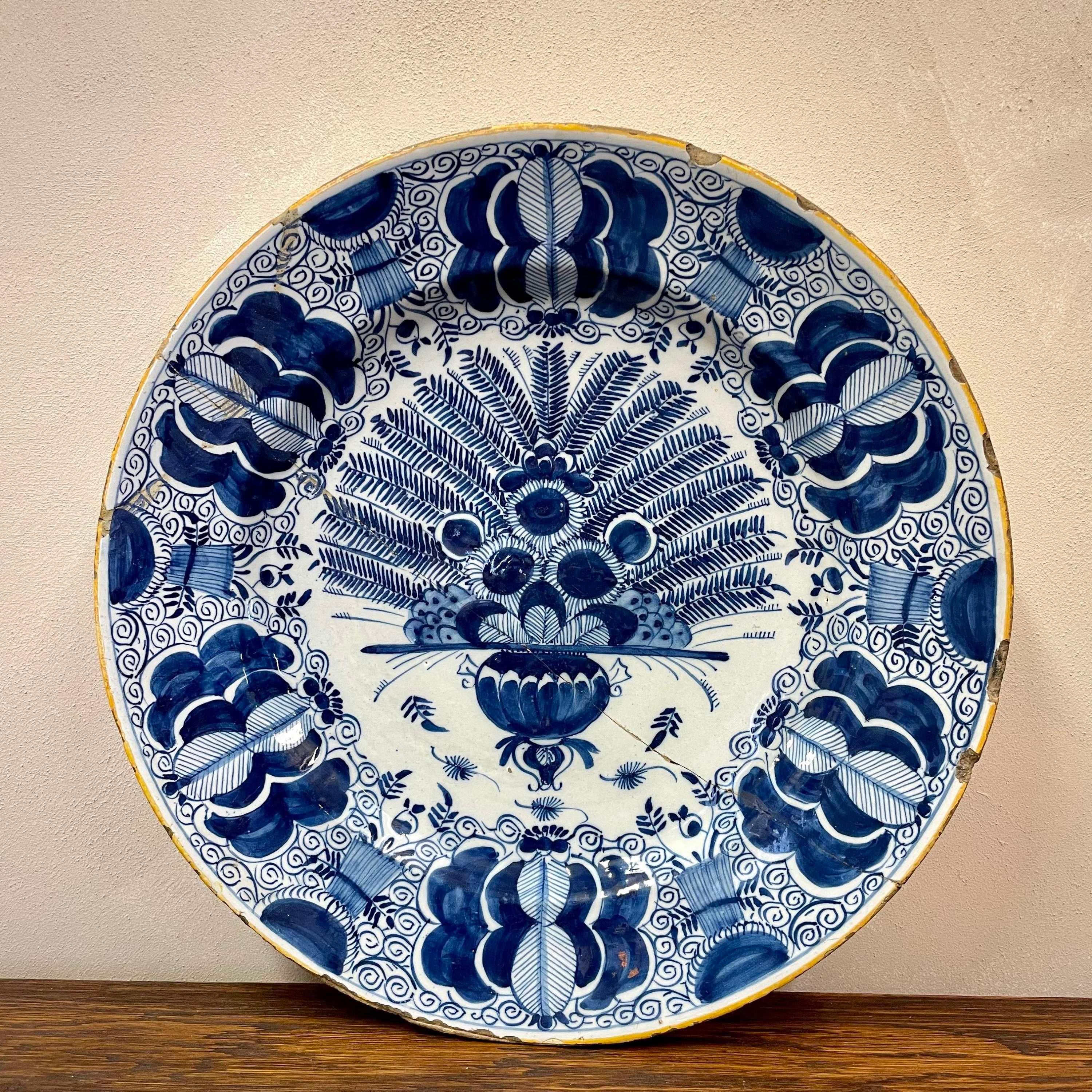 Dutch Delft Peacock charger.
circa 1750. 
Peacock feathers are displayed in a bulbous urn. 
The edge of the plate is glazed in ochre. 
Old repair. 35cm / 13.8'

More Delft on our profile 
To have a blue and white collection in one location