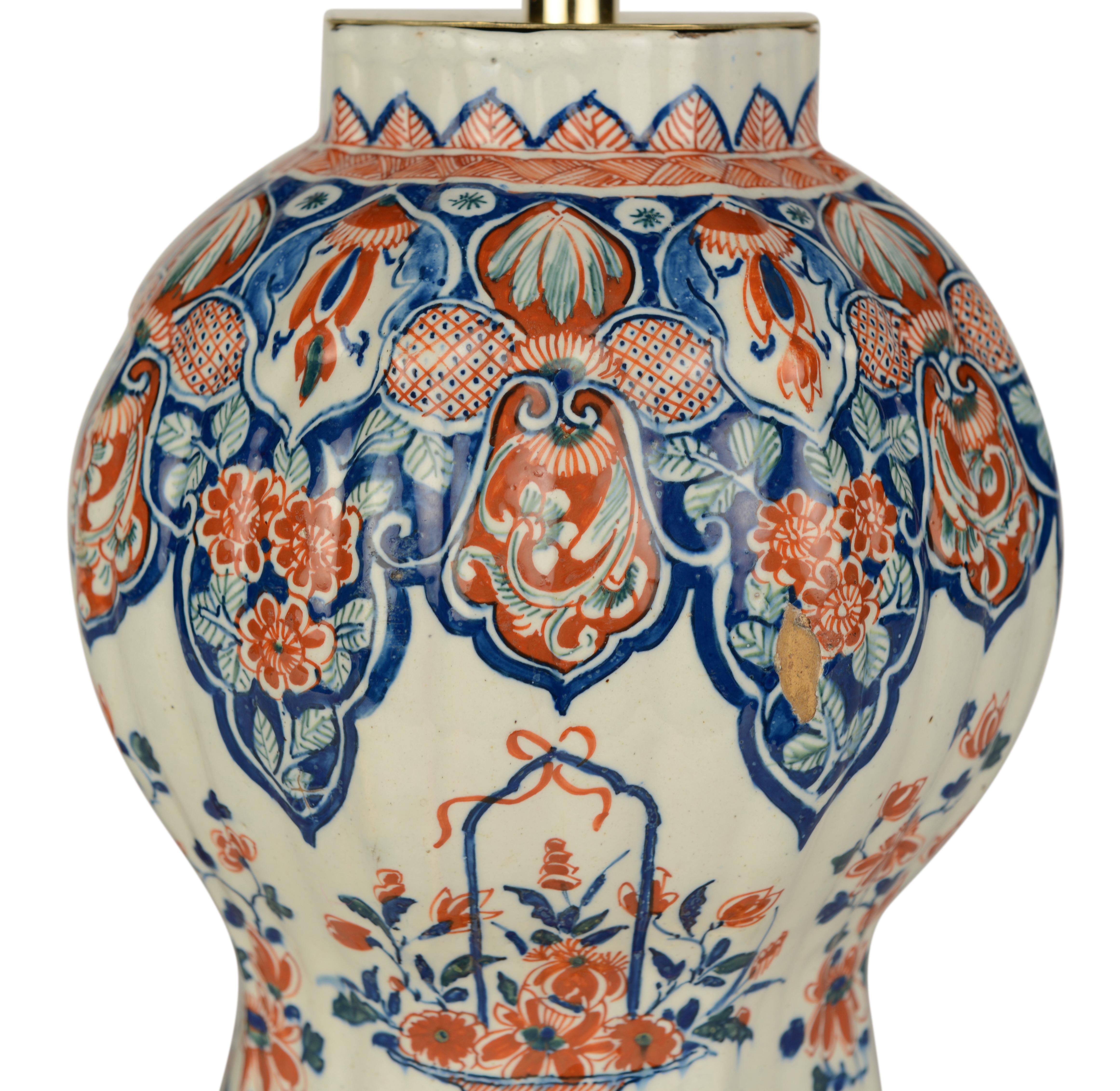 Un beau vase balustre à section octogonale nervurée et polychrome de Delft. Peint dans la palette du Cachemire dans des tons de bleu, de rouge fer et de vert, abondamment décoré de paniers de fleurs et de branches fleuries entre des bordures