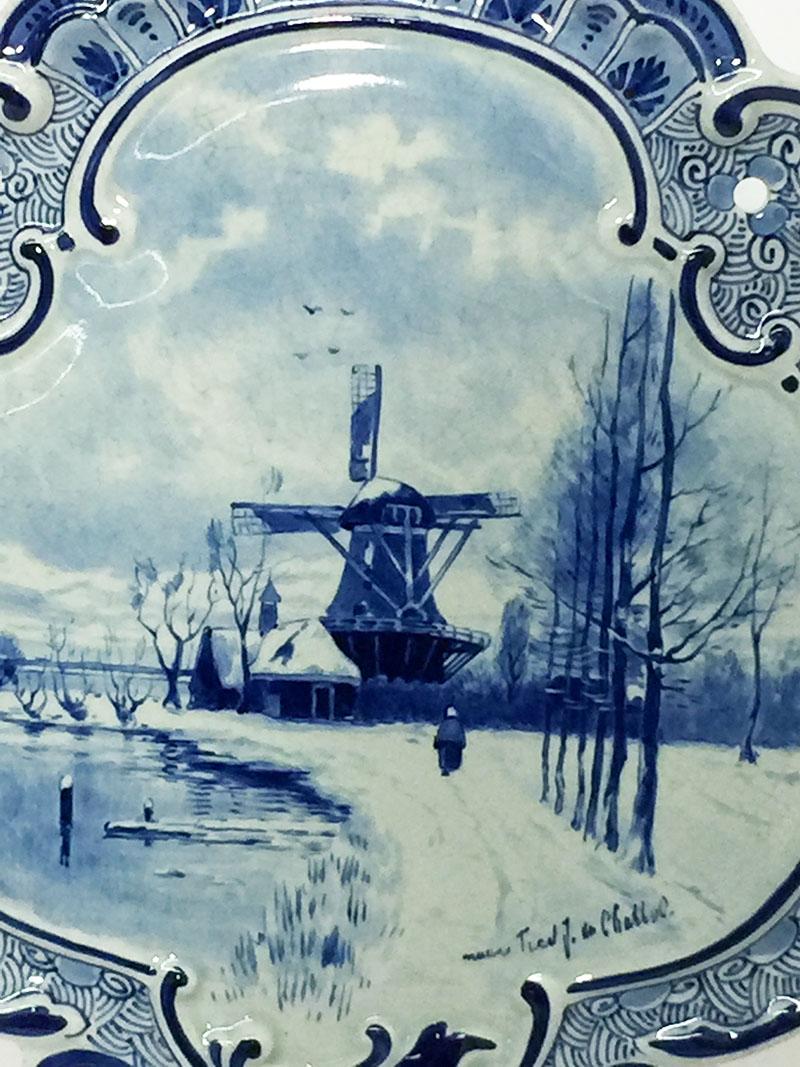 Small Dutch delft Porceleyne Fles applique after a painting by F.J. du Chattel, 1898

A shell shaped porcelain applique with in a medallion painted scene after a painting by Fredericus Jacobus van Rossum du Chattel (1856-1917). 
A windmill in a snow