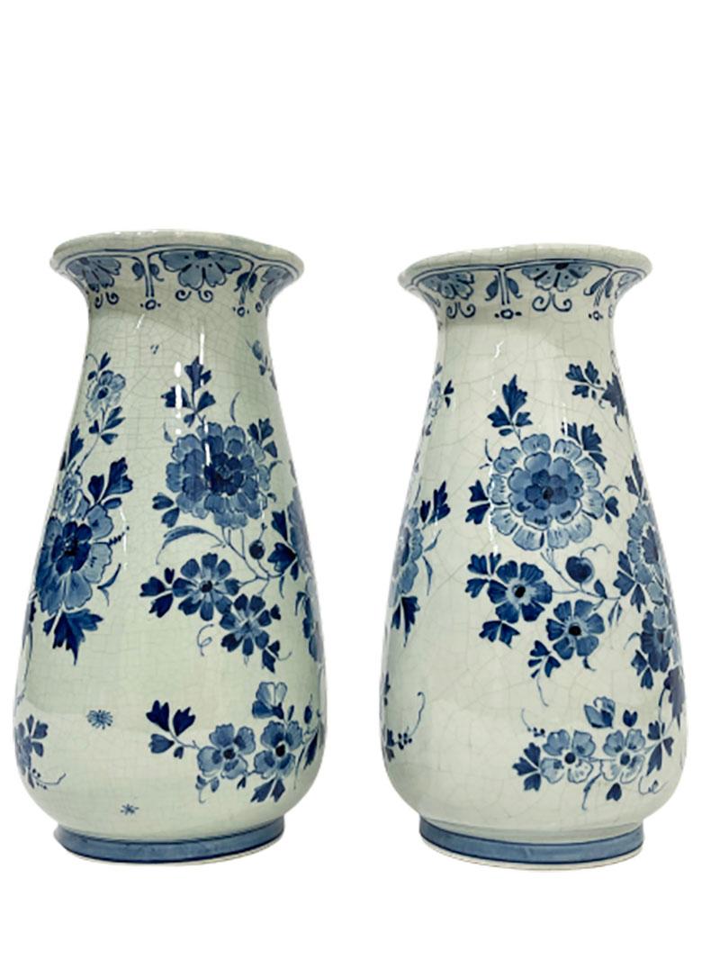 Dutch Delft Porceleyne Fles flower vases, 1890.

Delft earthenware Porceleyne Fles Delft flower vases with painted in medallion of flower tendrils a scene on water with boats. Painted on the back with floral decoration. The vase is round and oval