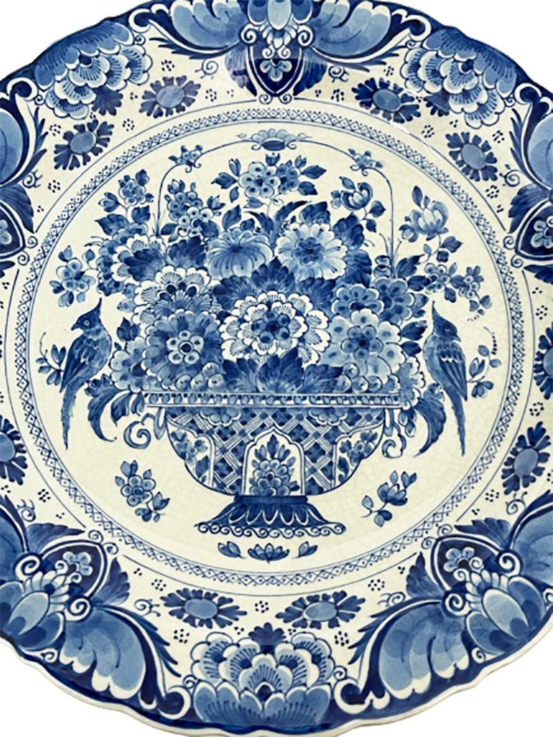 Dutch Delft Porceleyne Fles wall plate, 1948

A Dutch delft Porceleyne Fles wall plate with in medallion painted bouquet with flowers in vase with birds on each side. Floral decor on the edge. The rim has a scallop motif
The wall plate dates 1948,