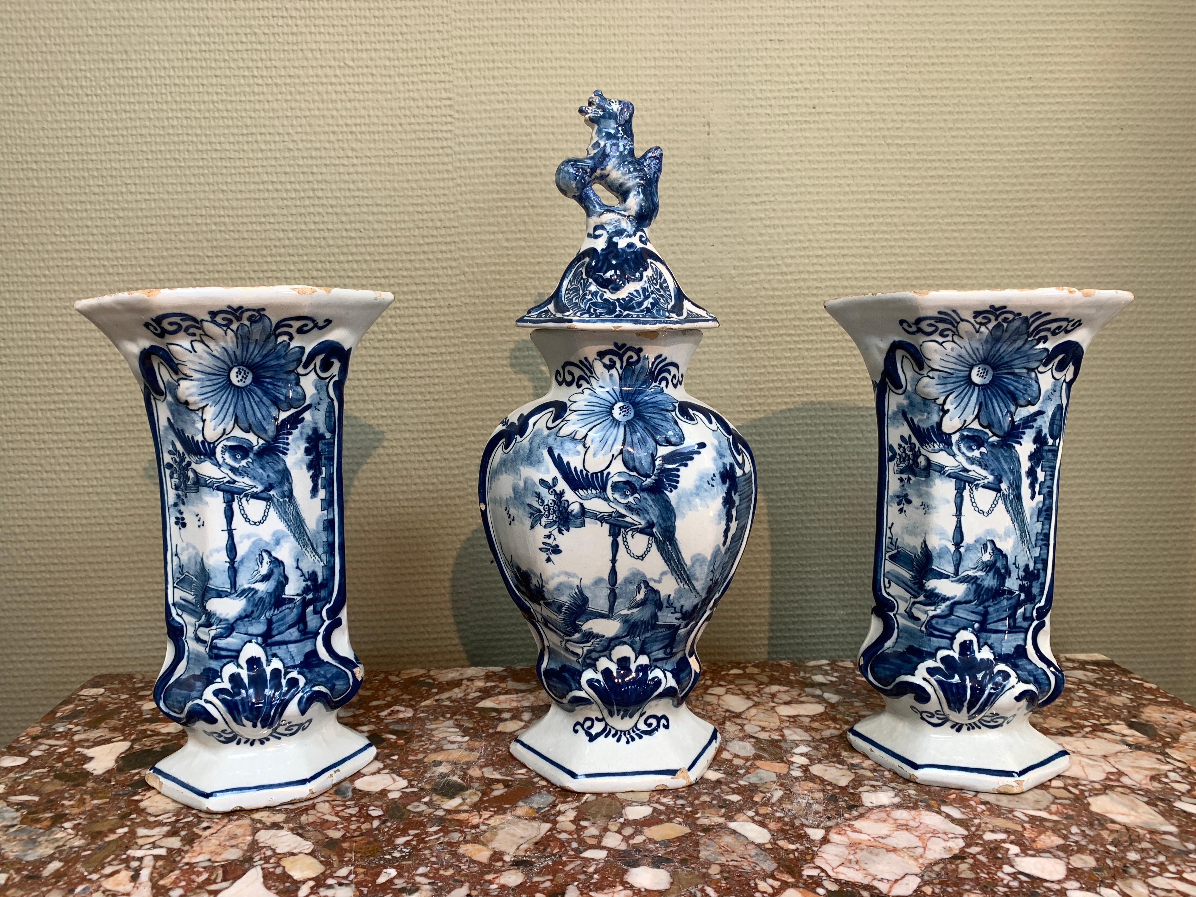 A Dutch Delft garniture of two side and one middle vase, decorated with a dog and parrot.

Origin: Delft, The Netherlands
Date: 1763 - 1806
Workshop: De Porceleyne Clauw
Owner: Lambertus Sanderus

A wonderful Dutch Delft Garniture with a decoration