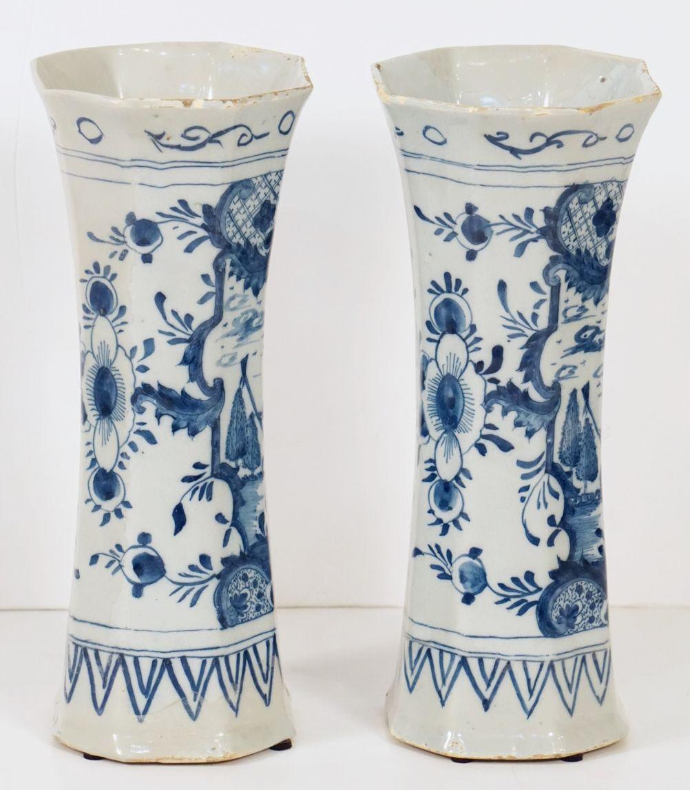 A fine pair of Delft vases in blue and white, c.1840, by the celebrated Dutch pottery firm of Jan Jansz. van der Kloot - each vase featuring a facing pastoral scene of a lady in crinoline dress, the reverse with a foliate design.

Bottom mark: Jan