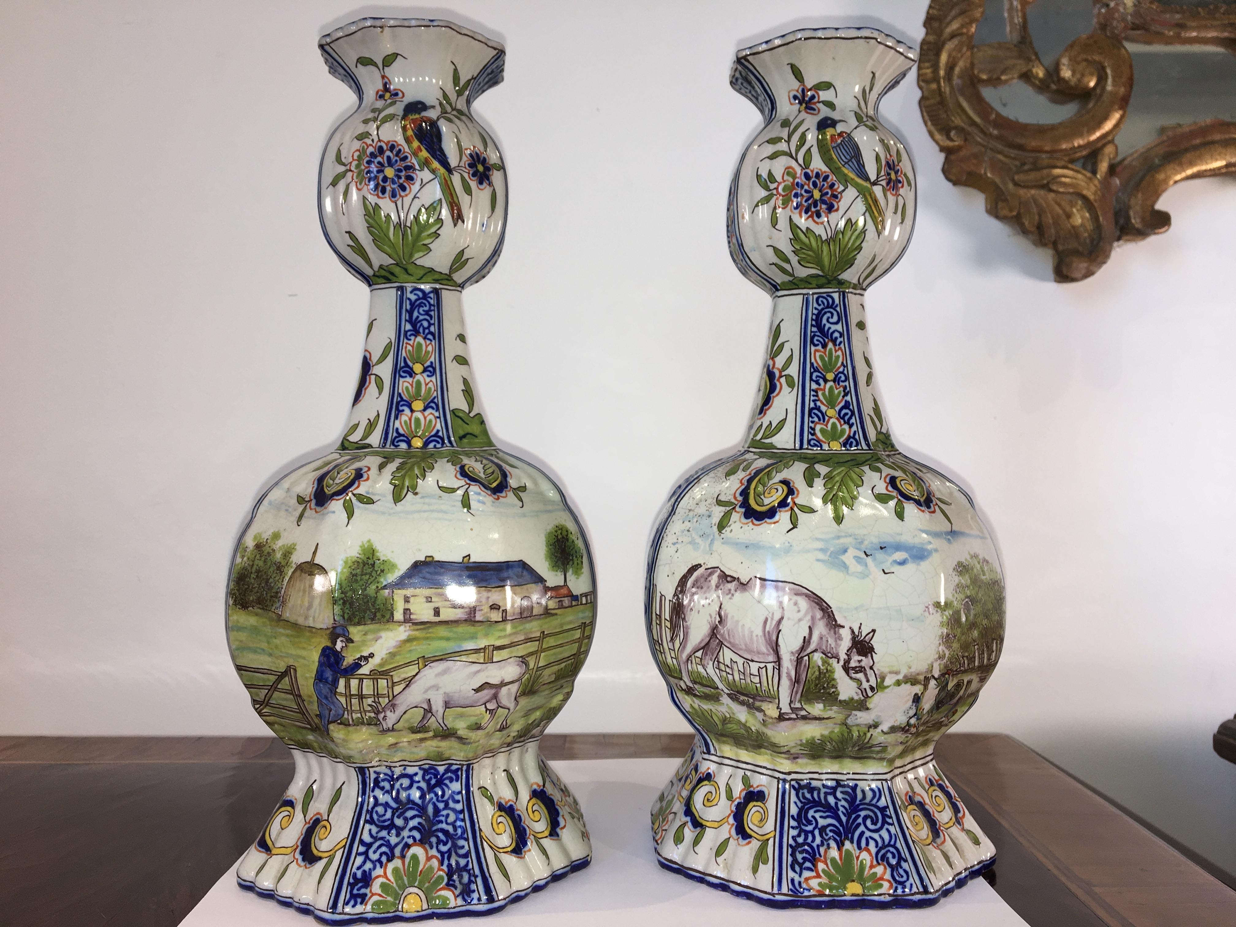 Pair of exceptional polychrome 18th-19th century delft vases with rare equestrian scenes, marked. The top portion of the vase features birds and flowers, the larger features riders, horses, and hounds on one side, cows, farm scenes on the reverse,