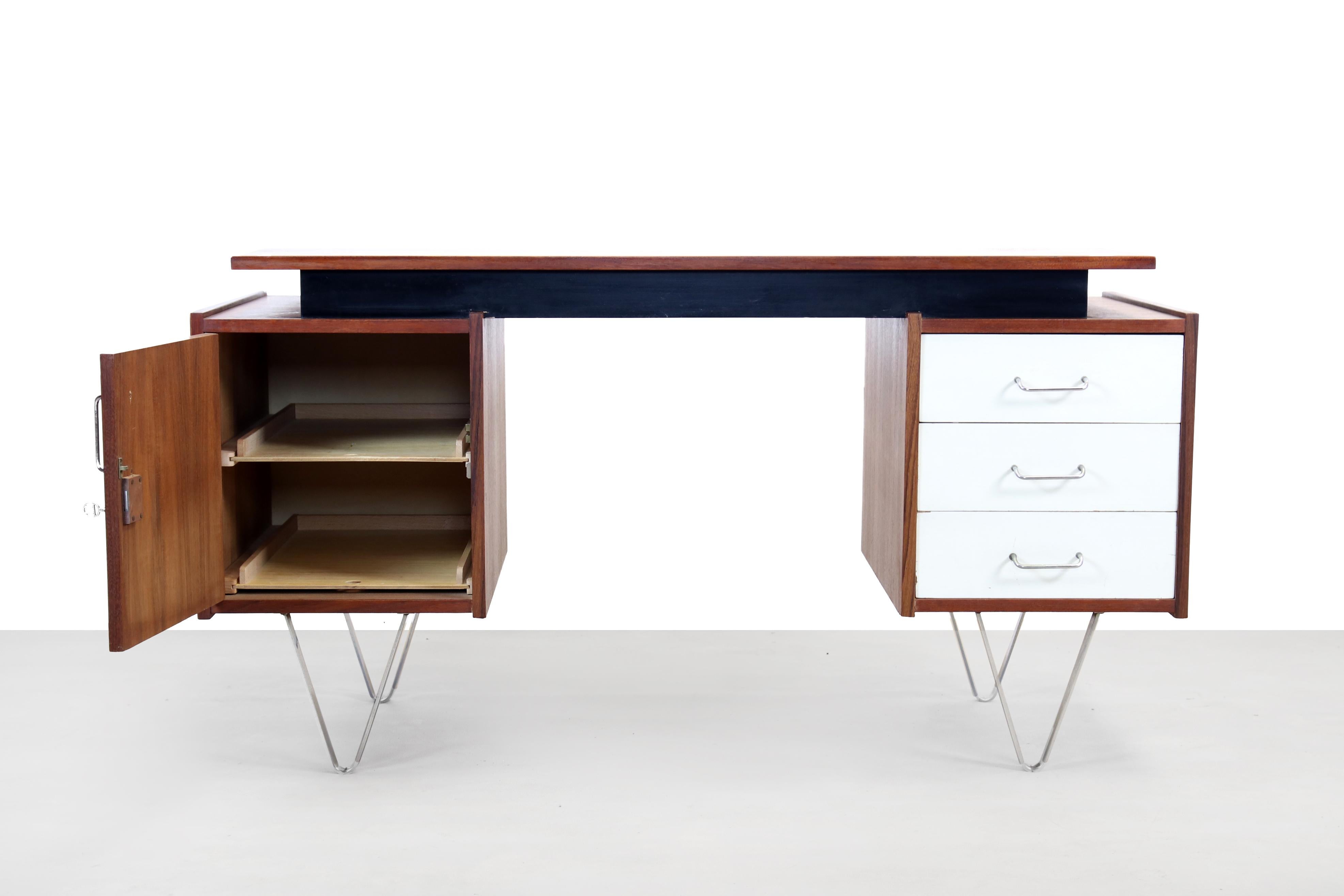 Minimalist and stylish desk designed by Cees Braakman for UMS Pastoe, The Netherlands in the early 1960s. This desk has a drawer unit with 3 drawers with white painted fronts on the right side and a compartment with a teak door on the left side. The