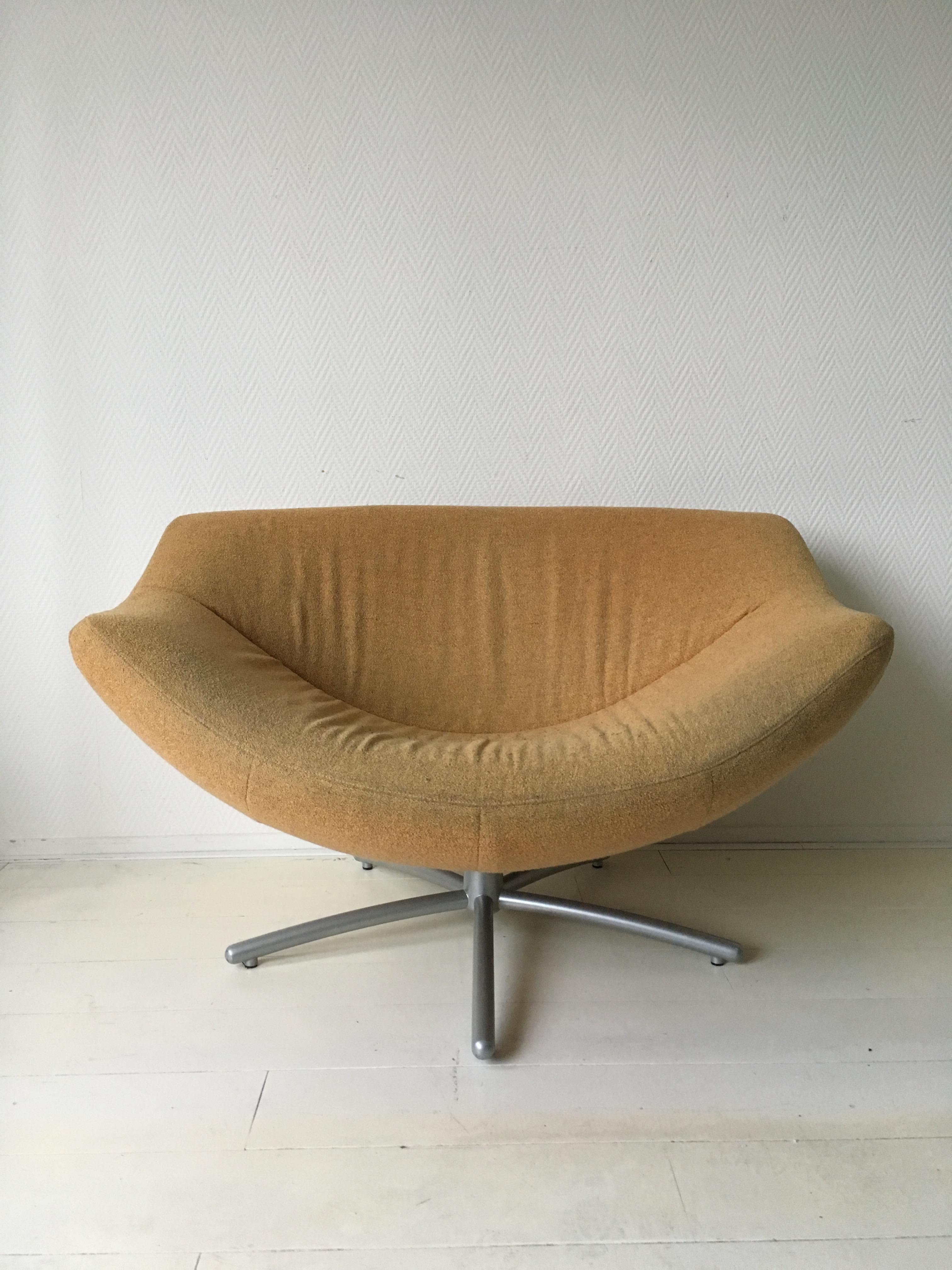 Wonderful swivel chair with yellow/orange replaceable upholstery and a metal base. Remains in good condition with some discoloration to the fabric and minor wear to it’s metal base. The fabric features a zipper. Original signed piece.