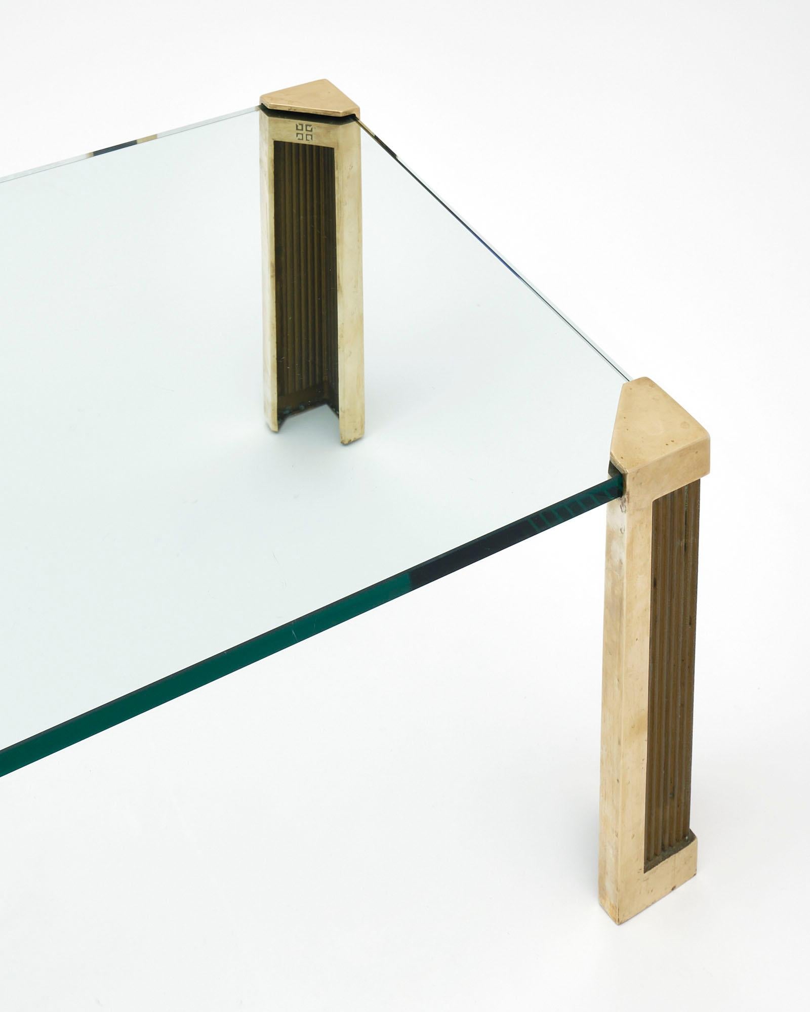 Table basse vintage du designer néerlandais Peter Ghyczy. Cette pièce présente un design sans cadre avec des pieds en laiton et un plateau en verre de qualité.