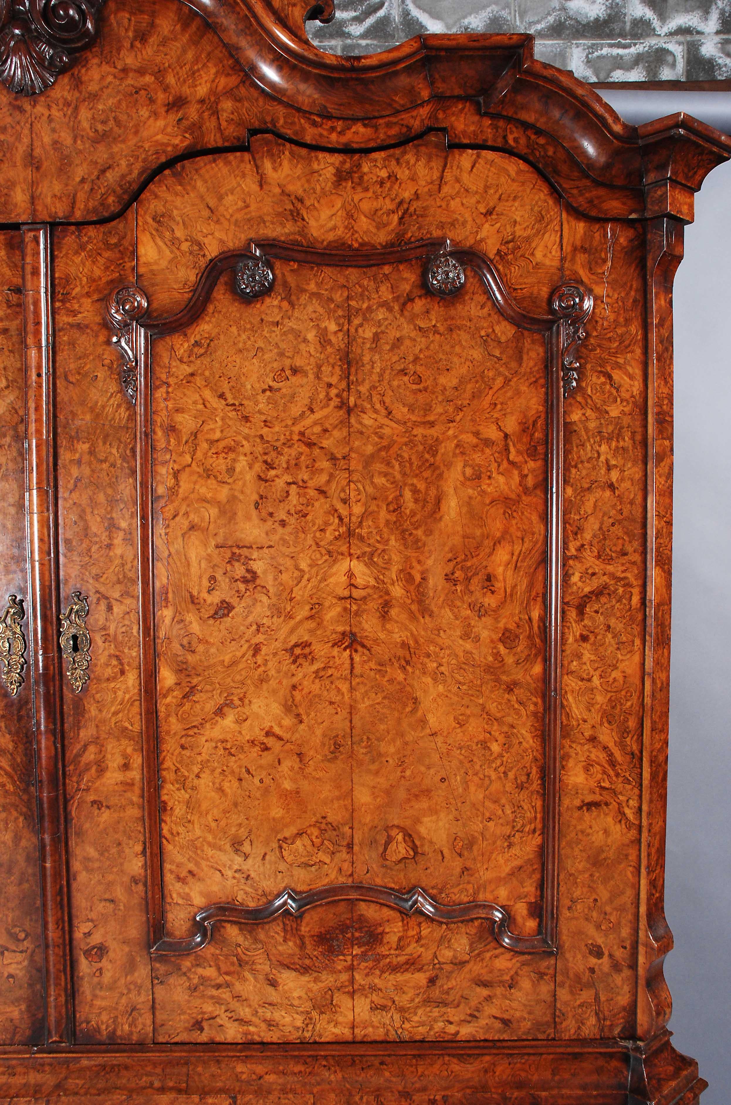 Eine schöne Qualität holländischen Presse in schön gemaserten Nussbaum furniert. Das gut geformte Gesims wird von einer Akanthusblattschnitzerei gekrönt und ist mit Sockeln zur Präsentation von Garnituren versehen. Die Paneele der Türen sind