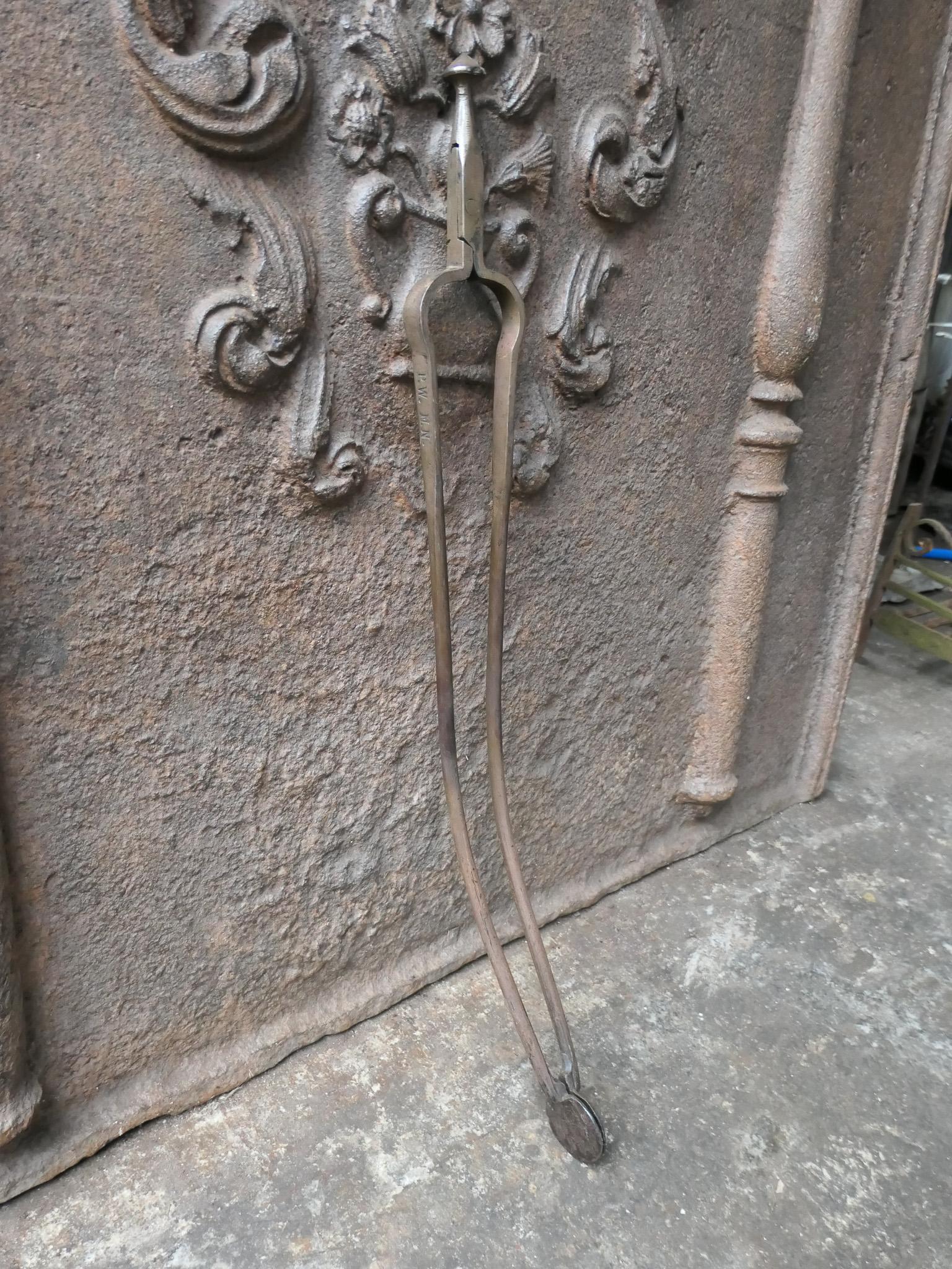 20th century Dutch Victorian style fireplace tongs made of wrought iron. The fire tongs are in a good condition and are fully functional.