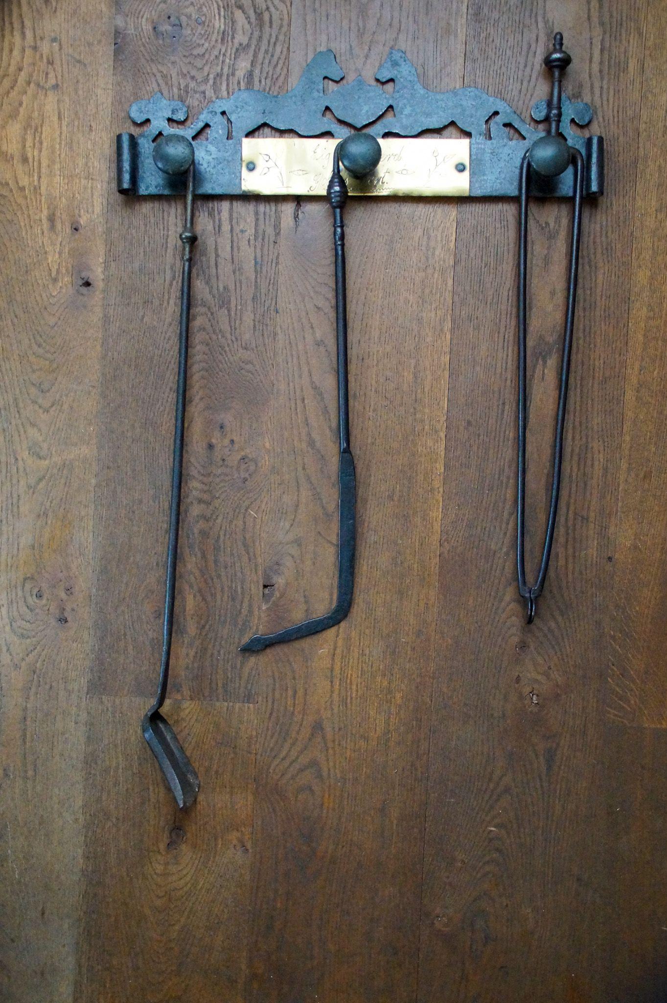 Early 20th century Dutch fireplace tool set consisting of fireplace tongs, a fire poker, a shovel and a hanger. The set is made of wrought iron and some brass. They are in good condition and are fully functional. Victorian Style.