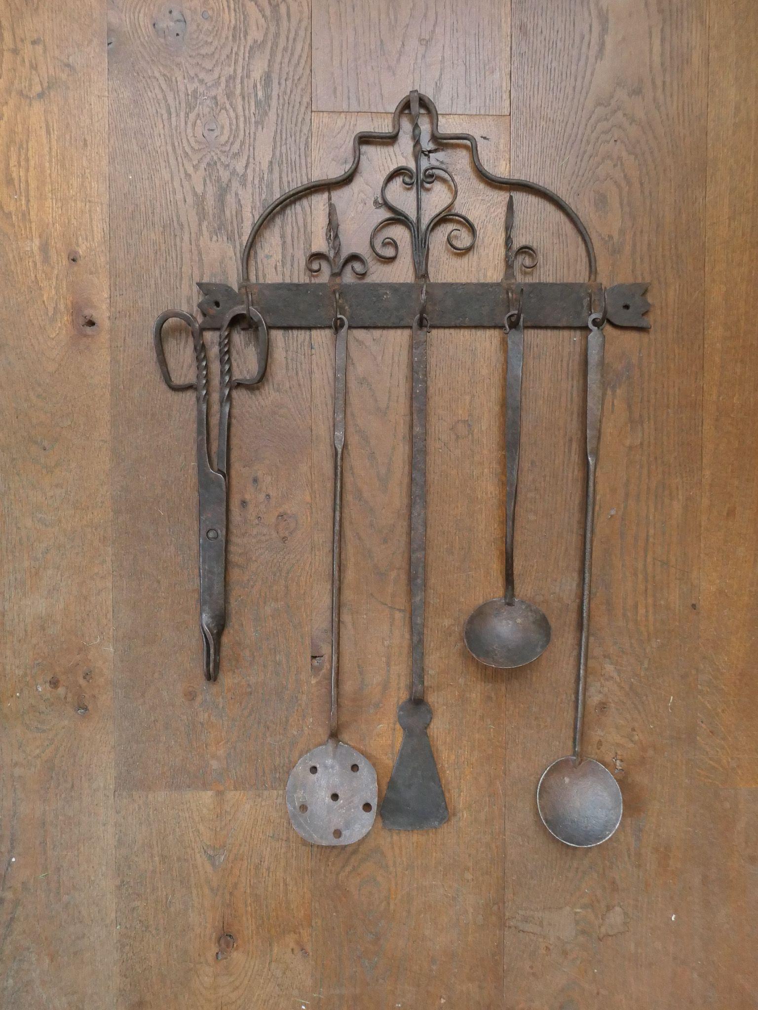 Set di utensili da camino del periodo neoclassico olandese dell'inizio del XIX secolo, composto da una pinza da camino, due mestoli, una schiumarola, una spatola e una gruccia. Il set è realizzato in ferro battuto. Sono in buone condizioni e