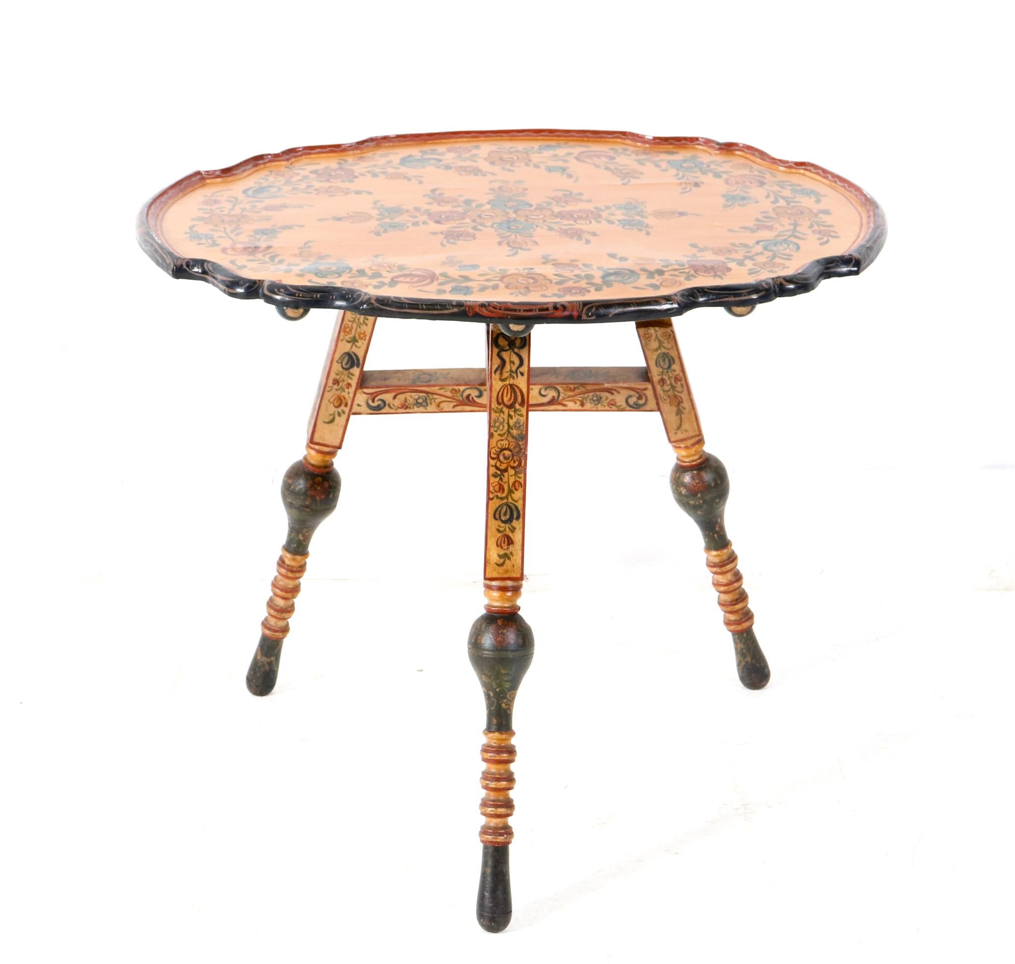 Magnificent and rare Folk Art Hindeloopen tilt top table.
Striking Dutch design from the 1900s.
Solid pine dished oval top, standing on a folding base with three turned splayed legs hand-painted with original polychrome paint in Hindeloopen