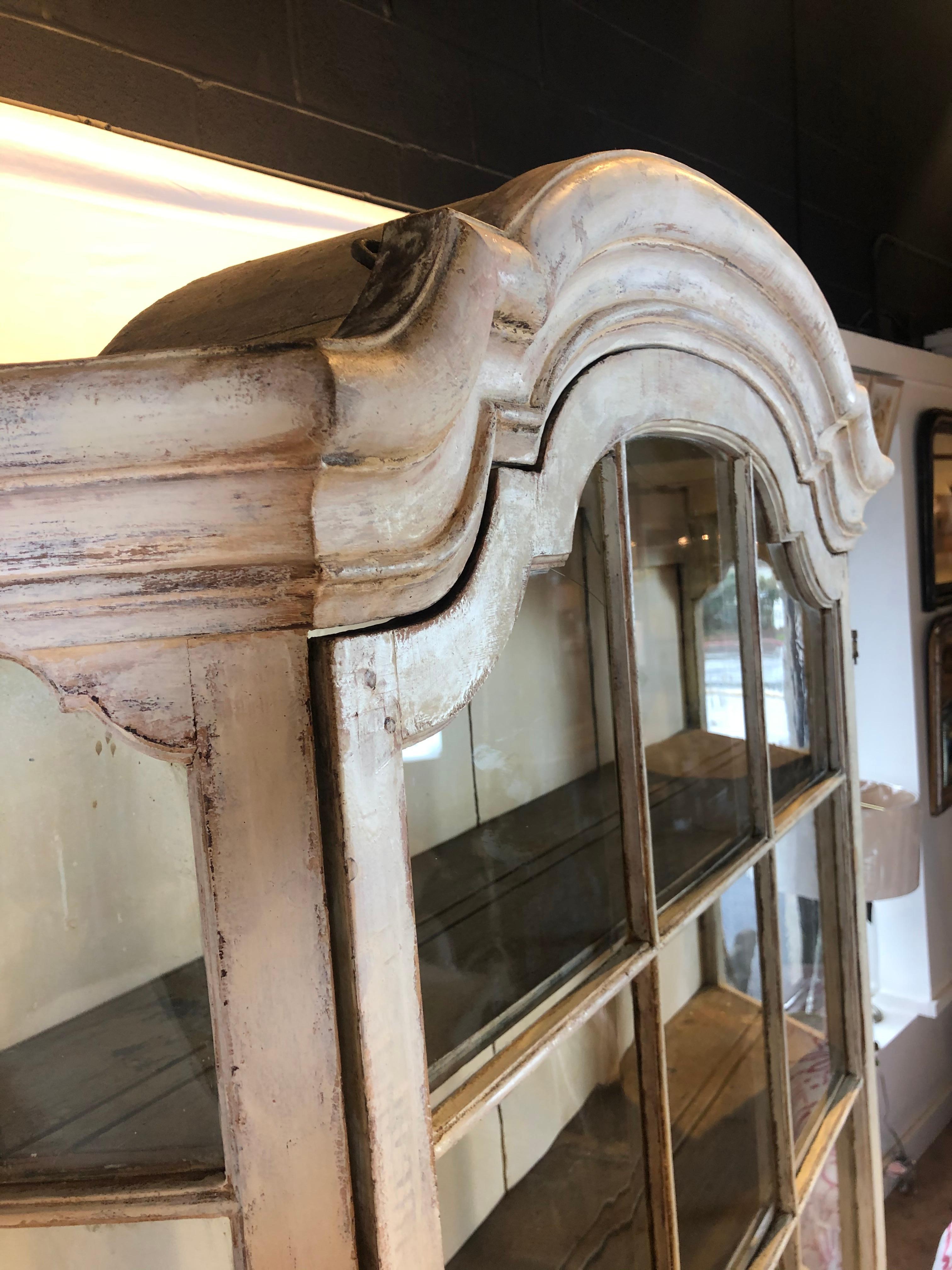 Ce meuble hollandais du 19e siècle est parfait pour n'importe quel décor. La partie supérieure comporte une porte à neuf carreaux en verre simple avec une tirette en laiton et des panneaux latéraux en verre. La partie inférieure comporte deux portes