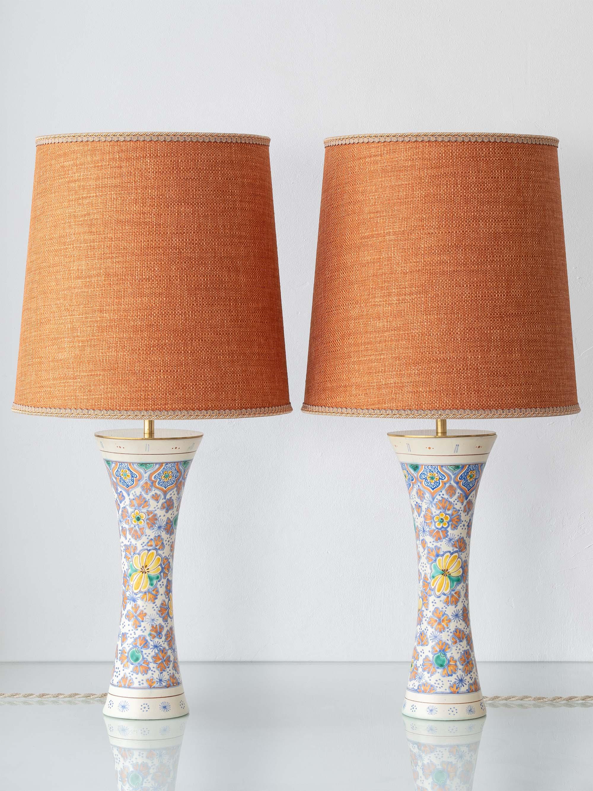 A colorful pair of Art Nouveau–Art Deco floral ceramic table lamps with bespoke burnt-orange shades—hand-painted in 1918 and newly rewired with U.S. plugs, ready for bedside tables, consoles, or living-room lighting.

This striking pair of table
