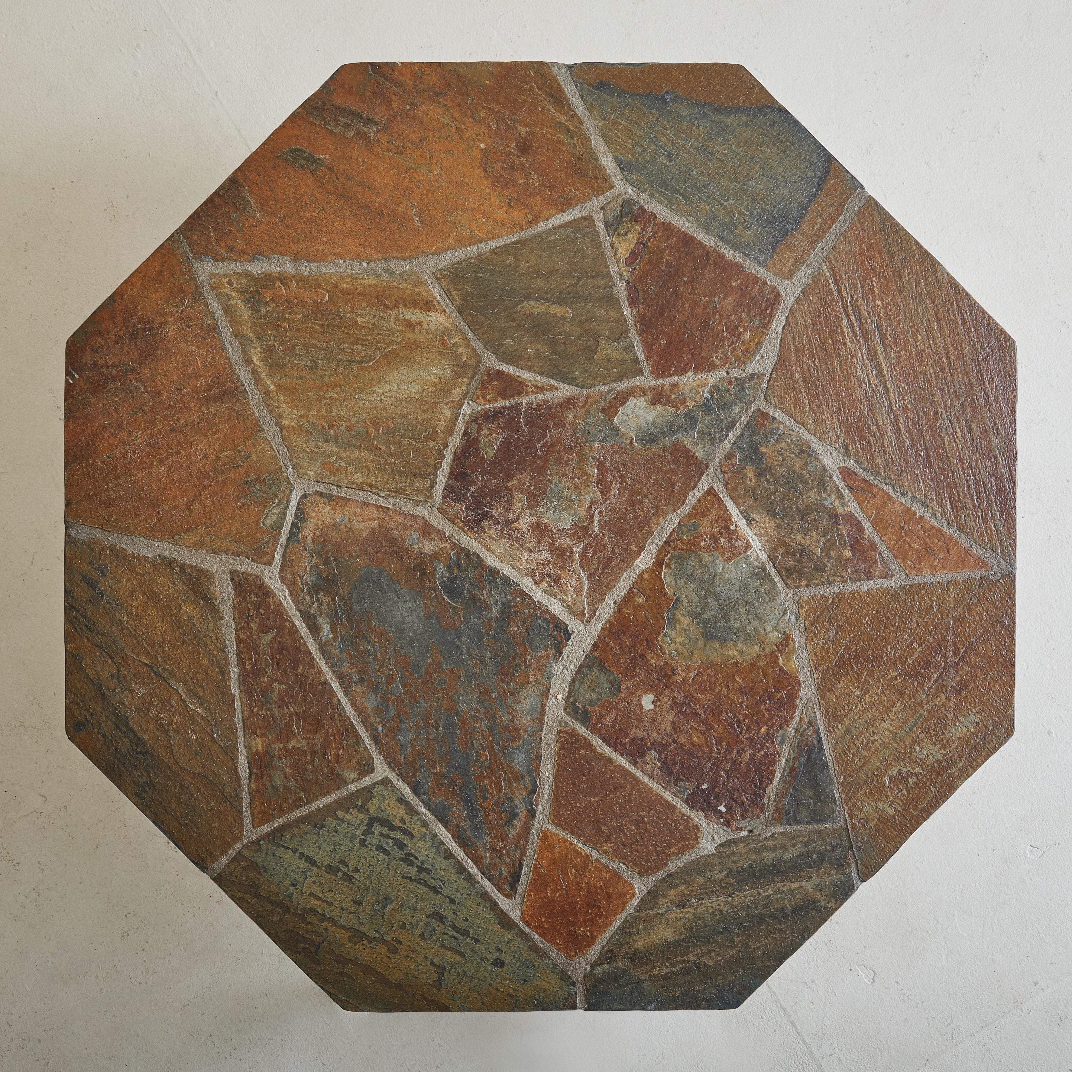 A 1960s hexagonal coffee table, attributed to Dutch sculptor Paul Kingma. The tabletop, a mosaic of richly colored stones, displays Kingma’s signature use of natural elements, each piece thoughtfully arranged to create a striking, organic pattern.