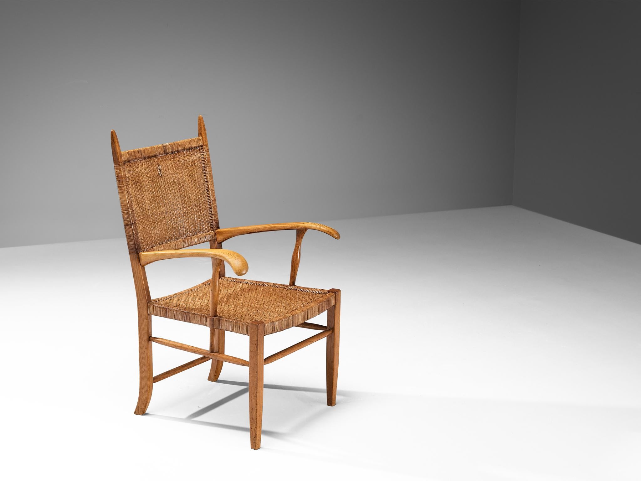 Armchair, ash, cane, The Netherlands, 1950s.

This elegant armchair features a warm ash wooden frame. Especially the stately high backrest makes this piece of furniture very remarkable. The backrest is furnished with woven cane, and blends nicely