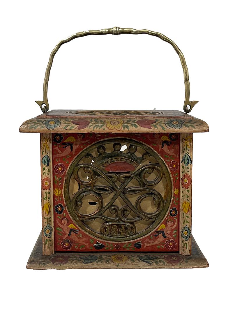 Dutch Hindeloopen square footstove, 1837

Square stove, decorated with carvings of 4 x Turkish knots and fitted with a swing brass handle. The foot stove was carried to the church at the time.  
A foot stove consists of a wooden box which is open on