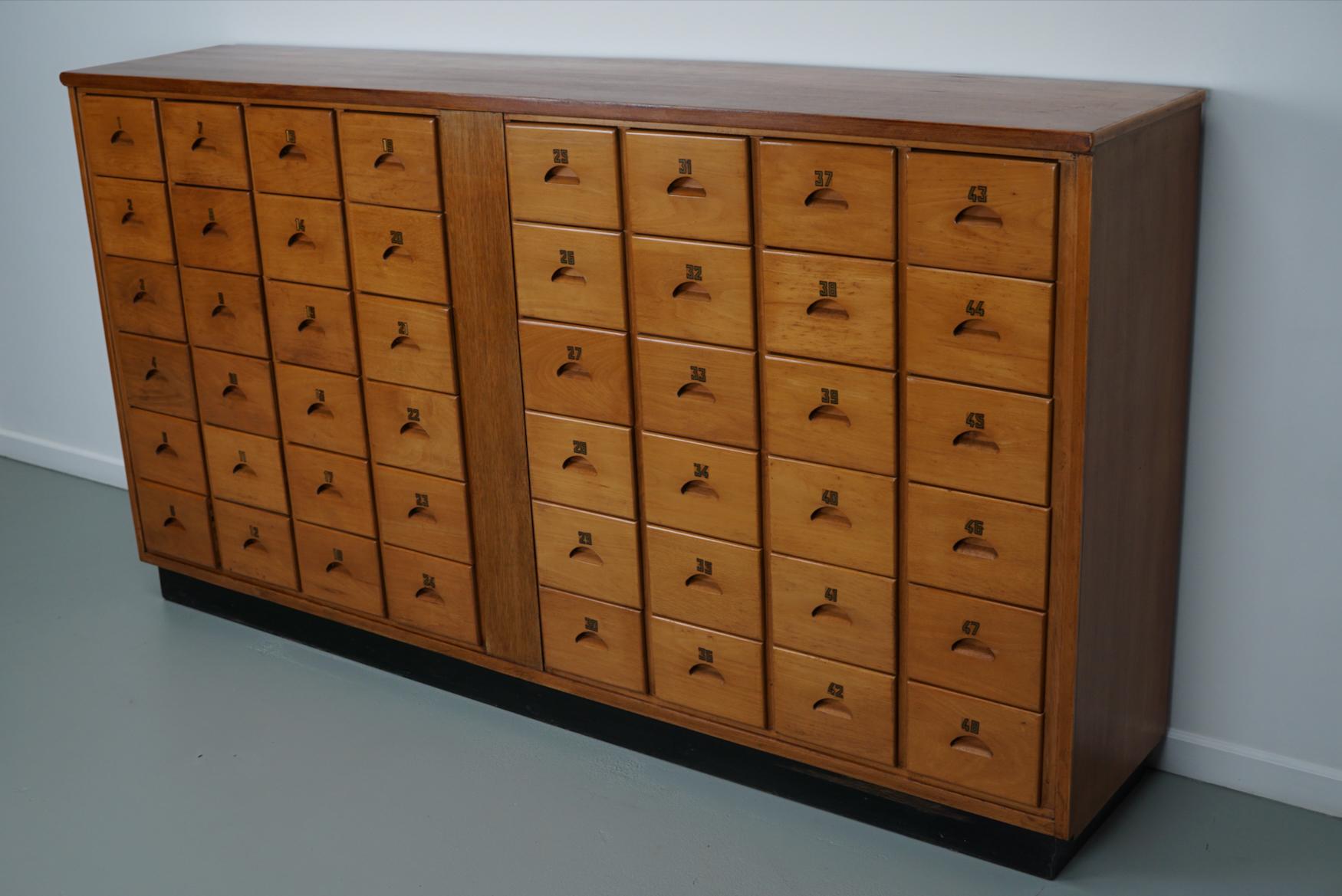 This apothecary bank of drawers was designed and made circa 1950/60s in the Netherlands. It was made from beech and it features 48 drawers with gold numbers. The interior dimensions of the drawers are: DWH 33 x 17.5 x 13 cm.