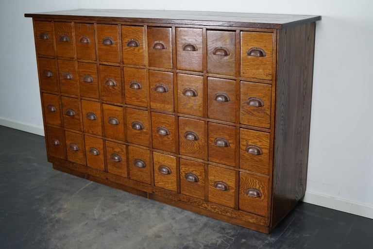 This apothecary cabinet was made circa 1940s in the Netherlands. The cabinet was used in a hardware store. It features 36 drawers with metal handles. The interior dimensions of the drawers are: D W H 39 x 13 x 19 cm.