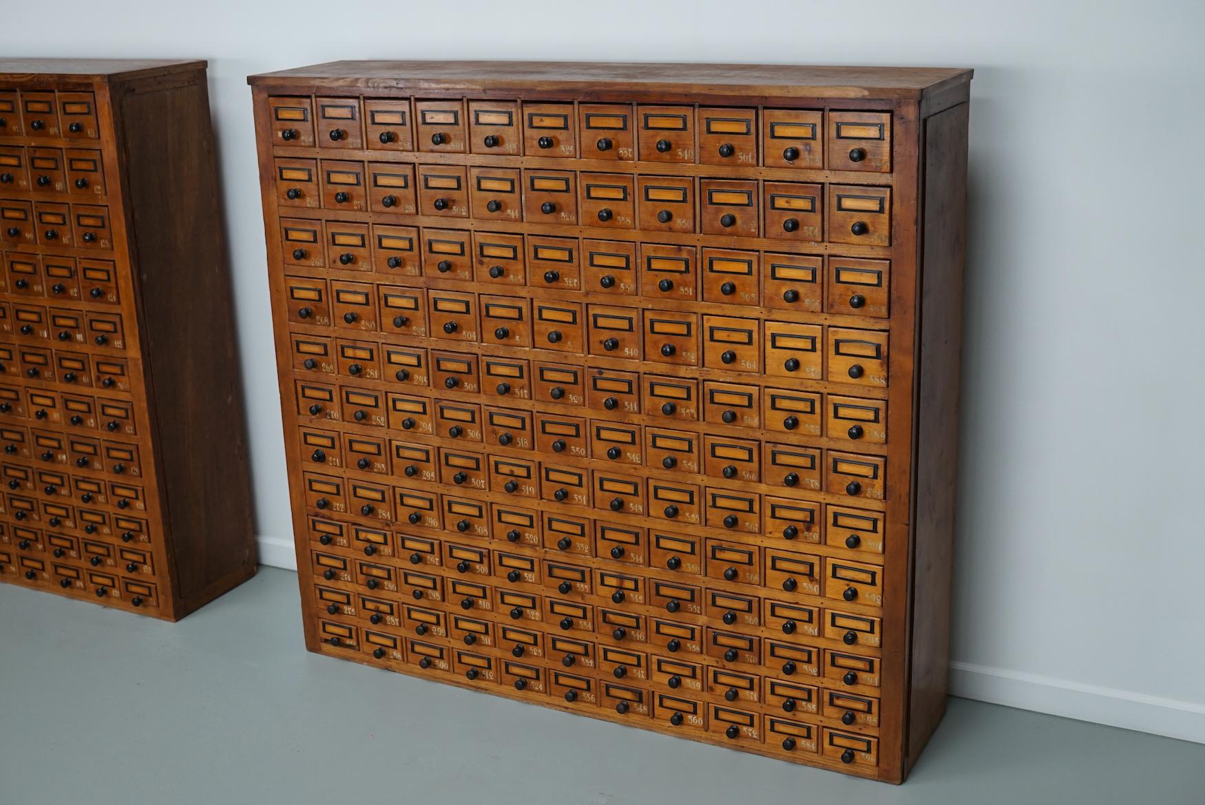 This workshop cabinet was made from pine in the Netherlands circa 1930s and it was used in a workshop for dentist equipment. It features many drawers with small knobs and name card holders. The interior dimensions of the drawers are: DWH 25 x 8 x 8,